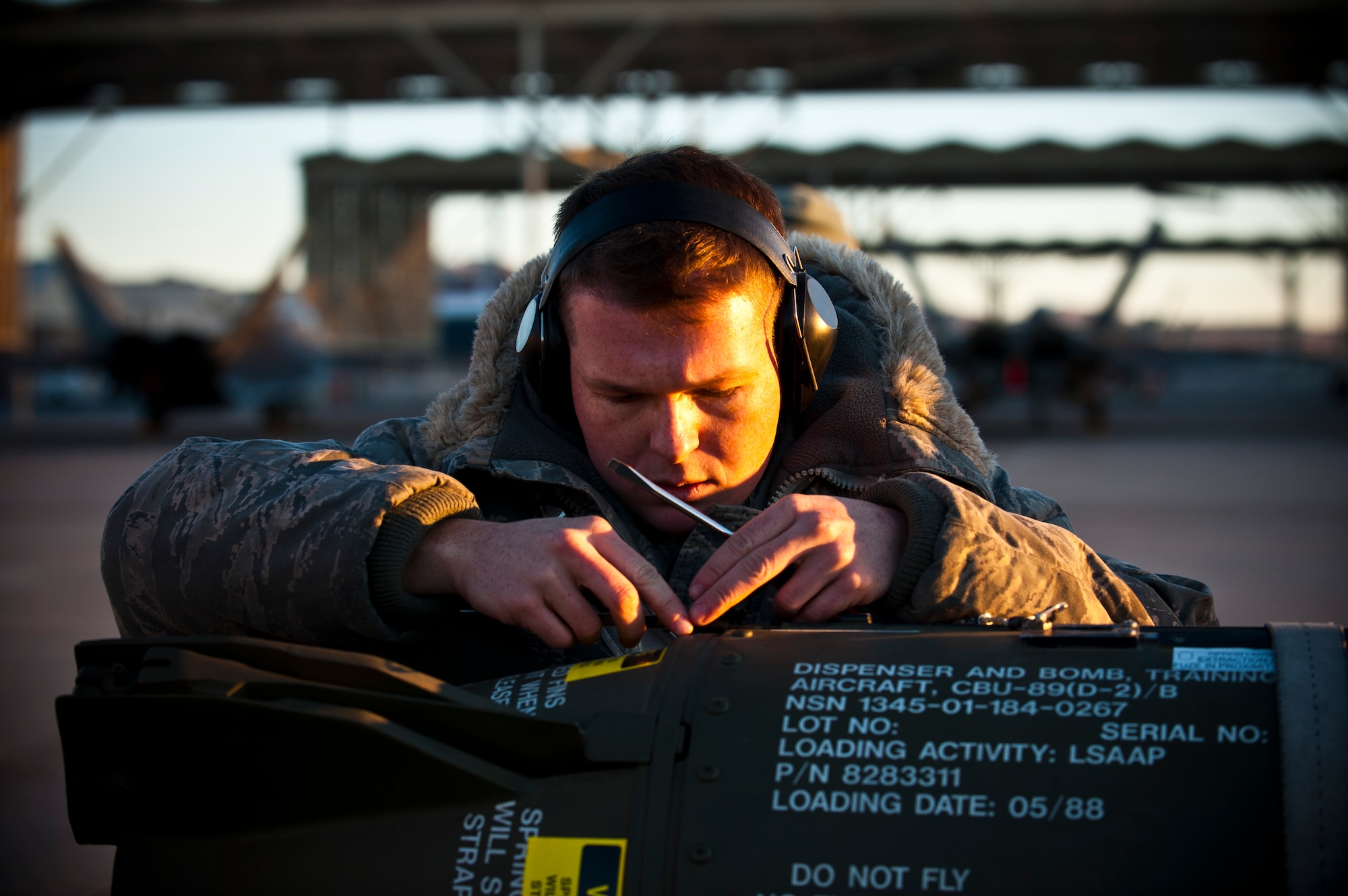 Airman 1st Class Ben Wilsey, 57th Aircraft Maintenance Squadron aircraft armament systems technician, conducts preparations on a CBU-89 bomb during a load crew competition Jan. 11, 2013, at Nellis Air Force Base, Nev. Airmen were tasked to upload munitions to two F-16 Fighting Falcons, three F-15 Eagles, one F-22 Raptor and one A-10 Warthog. (U.S. Air Force photo/Senior Airman Brett Clashman)
