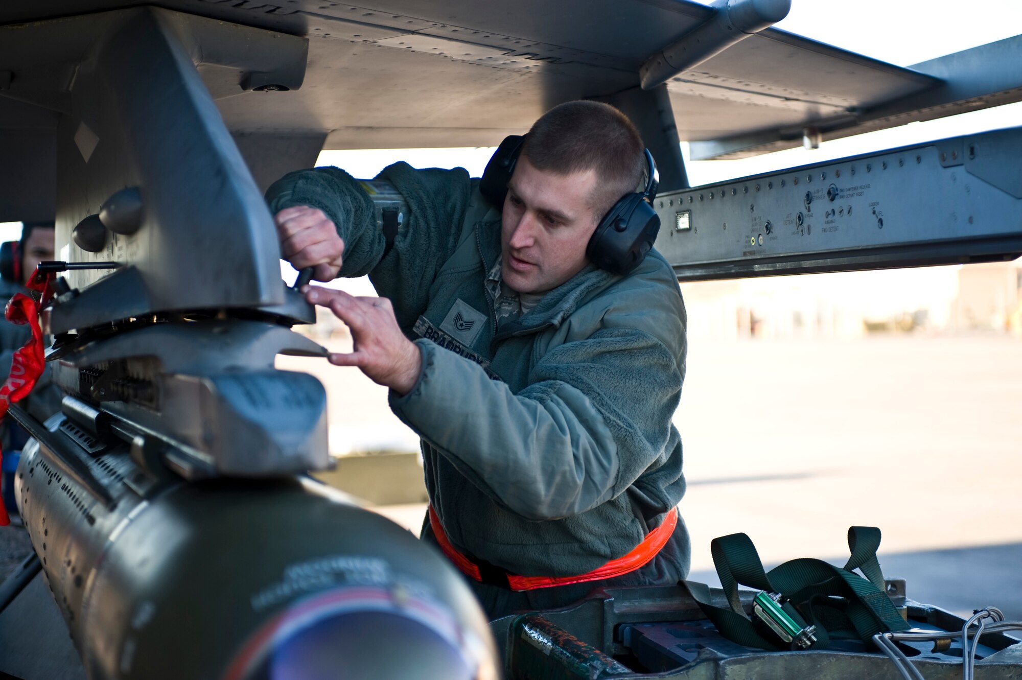 Staff Sgt. Bryan Bradbury, 57th Aircraft Maintenance Squadron aircraft armament systems technician, loads a CBU-89 bomb onto an F-16 Fighting Falcon during thr load crew competition of the year, Jan. 11, 2013, at Nellis Air Force Base, Nev. Airmen are graded on a written test, their composite tool kit, dress and appearance, and the load. (U.S. Air Force photo by Airman 1st Class Christopher Tam)