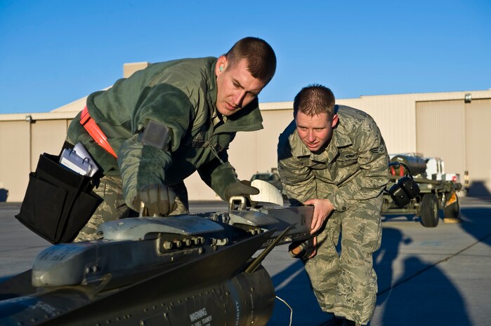 Staff Sgt. Bryan Bradbury and Senior Airman Jesse Potter, 57th Aircraft Maintenance Squadron aircraft armament systems technicians, prepare to load a CBU-89 bomb during the load crew competition of the year, Jan. 11, 2013, at Nellis Air Force Base, Nev. Load crew members are evaluated on their safety, speed, and use of the checklist. (U.S. Air Force photo by Airman 1st Class Christopher Tam)