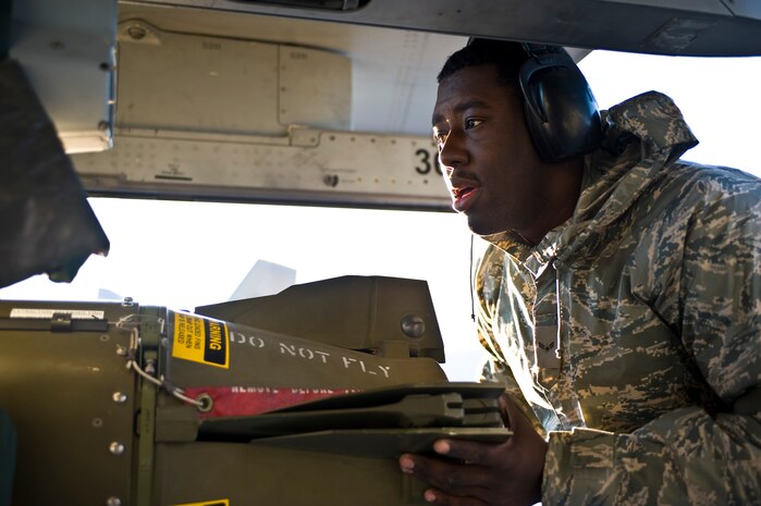 Airman 1st Class Jercorian Winters, 57th Aircraft Maintenance Squadron aircraft armament systems technician, loads a CBU-89 bomb onto an F-16 Fighting Falcon during the load crew competition of the year, Jan. 11, 2013, at Nellis Air Force Base, Nev. Load crew members must follow every step and take their time, ensuring timeliness and accuracy in weapons loading. (U.S. Air Force photo by Airman 1st Class Christopher Tam)