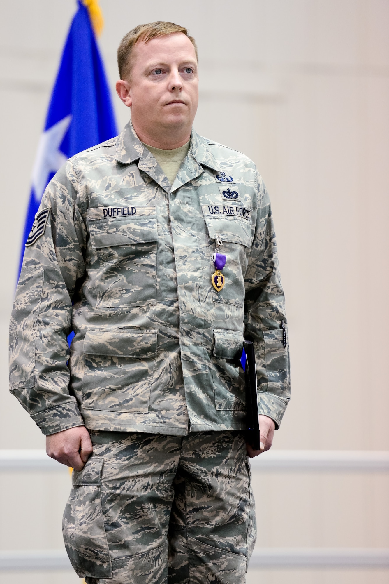 Air National Guard Tech. Sgt. Barry Duffield, 116th Civil Engineering Squadron, Explosive Ordnance Disposal Flight team leader, stands at attention after receiving the Purple Heart Medal from U.S Air Force Gen. Mike Hostage, commander, Air Combat Command, during a ceremony at Robins Air Force Base, Ga., Jan. 7, 2013.  Duffield received the medal for injuries sustained from an Improvised Explosive Device while deployed to Afghanistan in 2011.  During the same deployment, Duffield earned the Bronze Star and Air Force Combat Action Medal.  (National Guard photo by Master Sgt. Roger Parsons/Released)