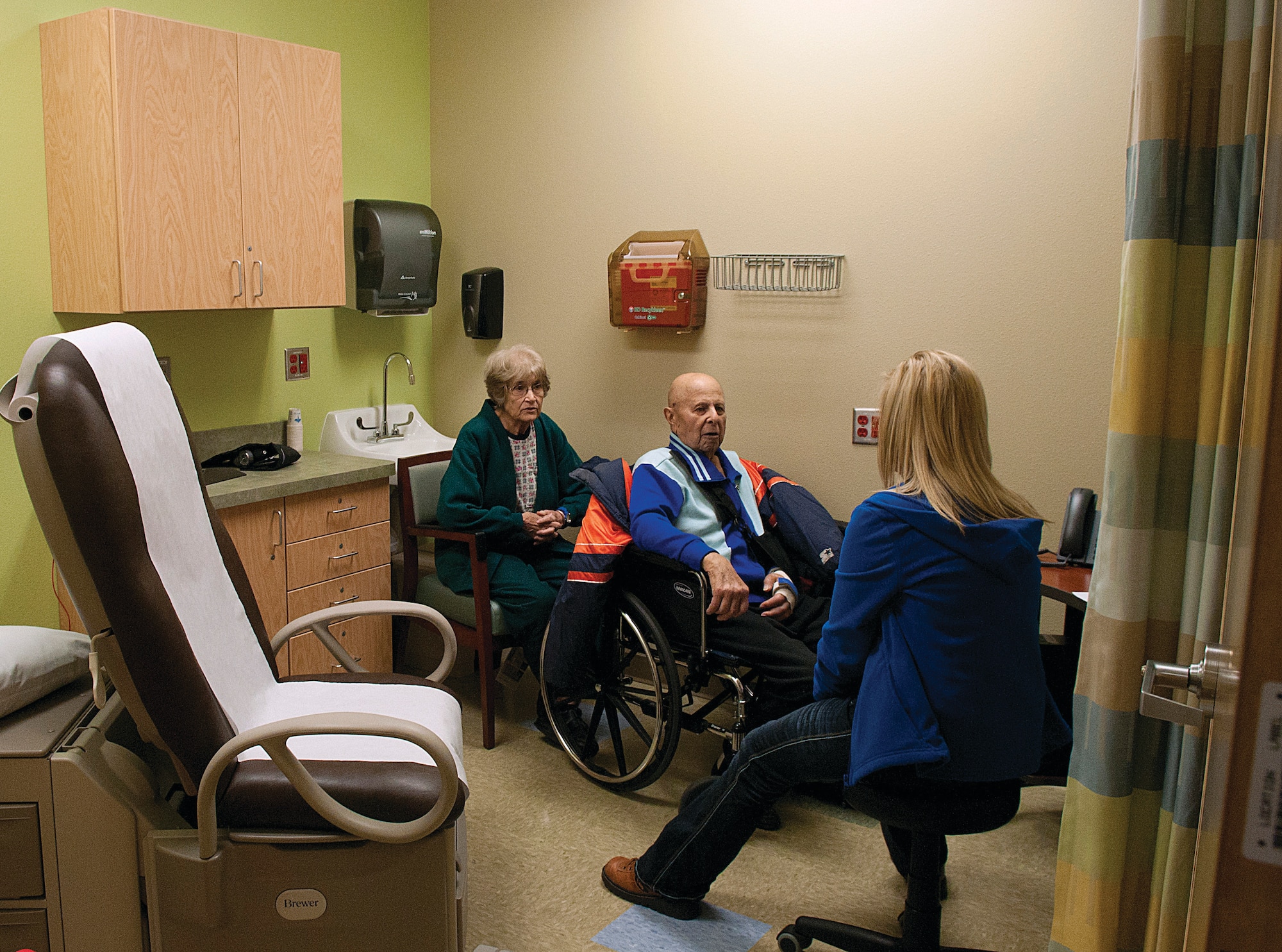 World War II veteran Gene Risha and his wife talk with Sandee LaRue, Veterans Affairs nurse, Jan. 4 in one of the new exam rooms in the recently opened Arrowhead Building at the Cheyenne Veteran Affairs Medical Center. LaRue said the new wing comprises more than 40 exam rooms for the Primary Care Clinic, which is an increase from the 16 the VAMC had before.  According to a VA spokesman, with the Primary Care Clinic moving into its new space room is freed up in the older building for other clinics to expand also. (U.S. Air Force photo by R.J. Oriez)