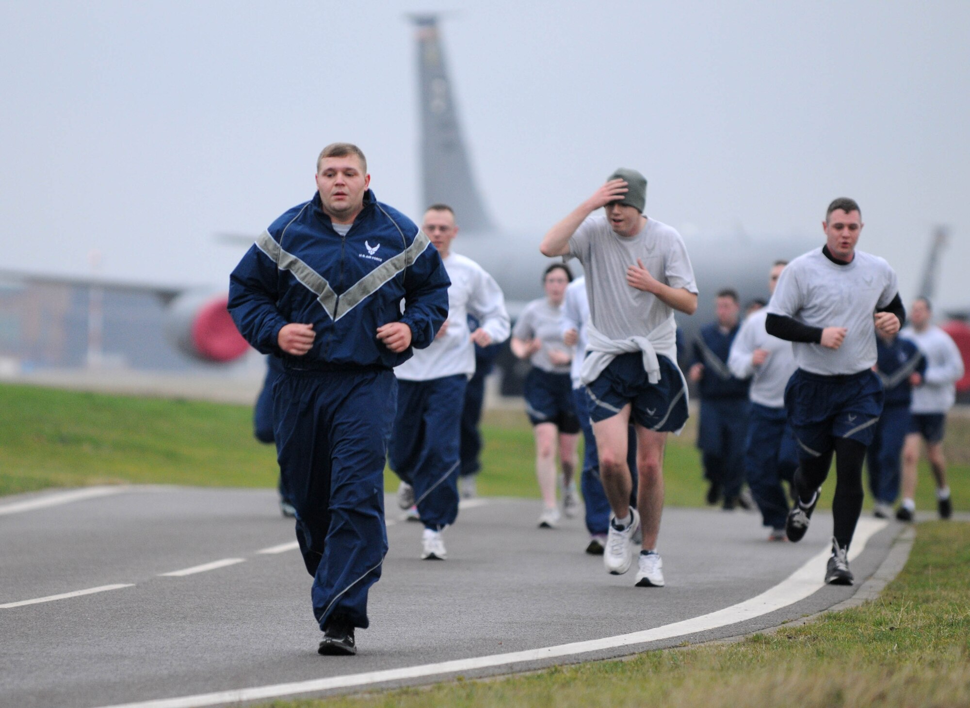 With the flightline as a backdrop, members of Team Mildenhall sweat it out during the wing run Jan. 11, 2013, at RAF Mildenhall, England. The monthly 5K run encourages morale and camaraderie throughout the base through exercise and healthy competition. (U.S. Air Force photo by Staff Sgt. Austin M. May/Released)