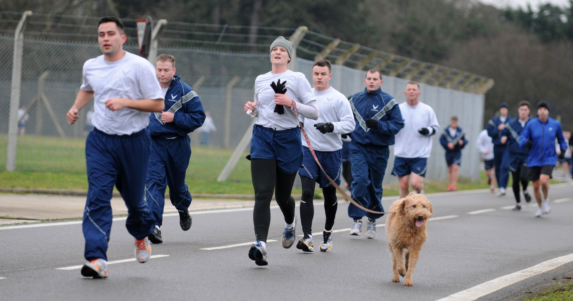 Members of Team Mildenhall - of the two- and four-legged variety - approach the final mile of the wing run Jan. 11, 2013, at RAF Mildenhall, England. The monthly 5K run encourages morale and camaraderie throughout the base through exercise and healthy competition. (U.S. Air Force photo by Staff Sgt. Austin M. May/Released)