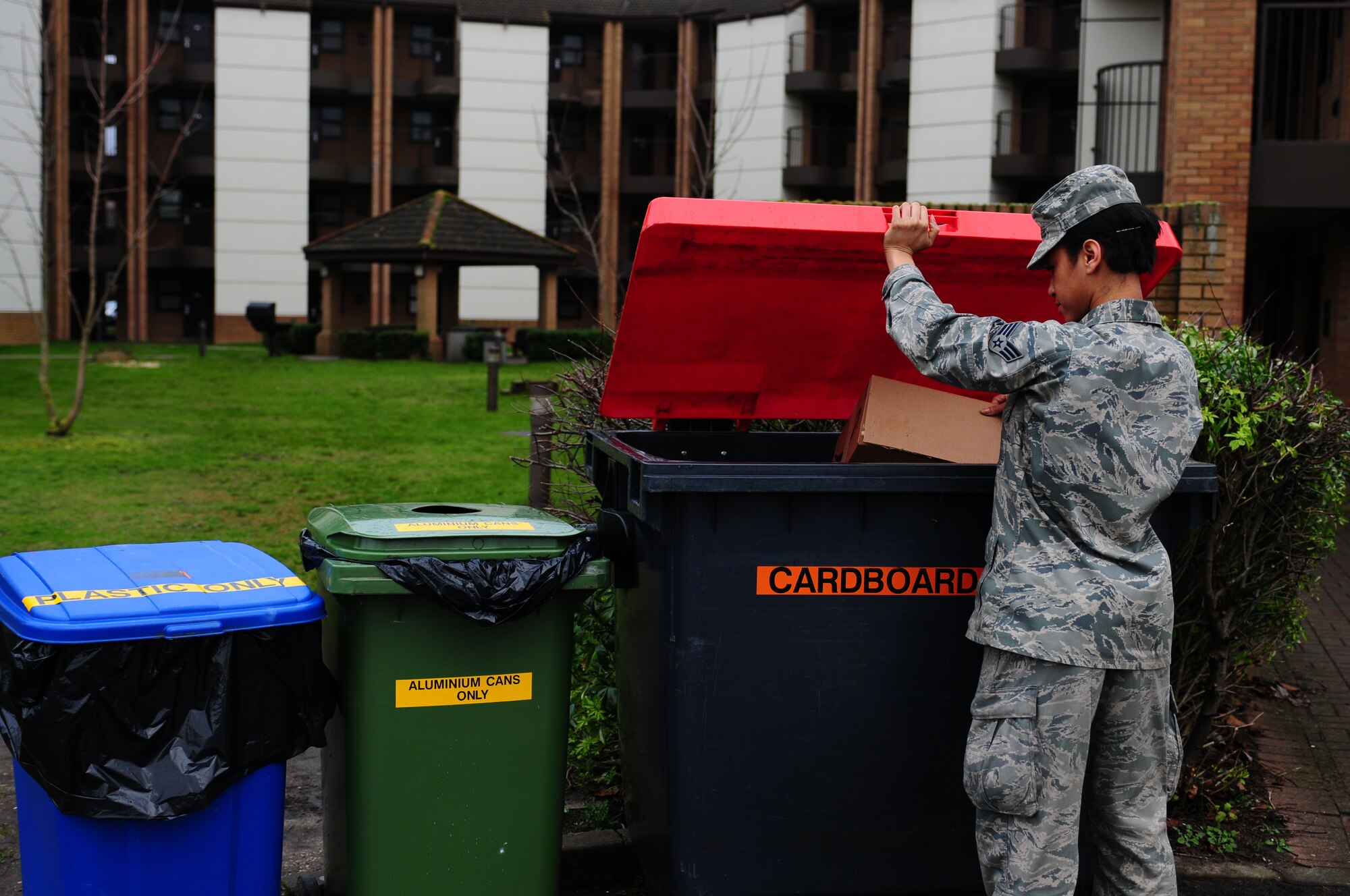 ROYAL AIR FORCE LAKENHEATH, England - Senior Airman Conswaila Jackson, 48th Munitions Squadron armament systems technician, recycles a cardboard box outside of the 48th Maintenance Group dorm Jan. 11, 2013. Dorm councils initiated a recycling program in the dorms last year and are now able to see results after recently adding aluminum and plastic recycling bins. (U.S. Air Force photo by Airman 1st Class Dana J. Butler)
