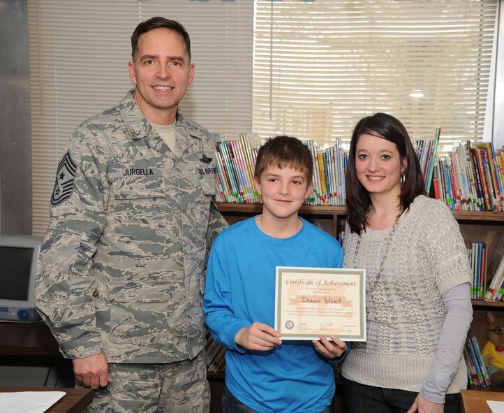 MINOT AIR FORCE BASE, N.D. -- Isaac Yatzeck, a student at Dakota Elementary, receives the 2013 National Geographic Bee school-level award from Chief Master Sergeant Kevin Jurgella, 5th Bomb Wing command chief here, Jan. 9. Yatzeck will now go on to compete at next level of competition to determine the state’s competitors. (U.S. Air Force photo/Airman 1st Class Andrew Crawford)