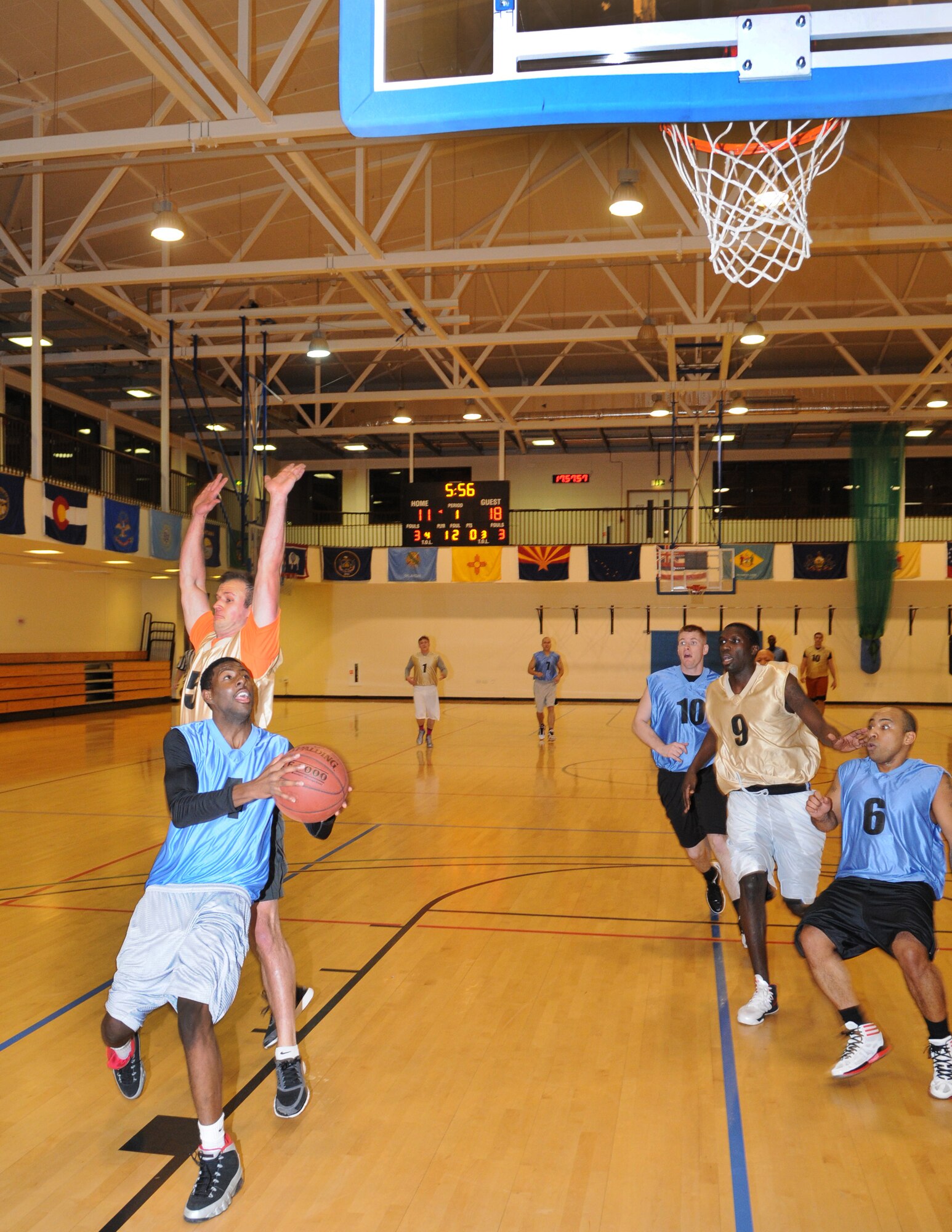 Airman 1st Class Jeffrey Williams, 352nd Special Operations Support Squadron aviation resource manager drives the ball in for a layup Jan. 10, 2013, during an intramural basketball game between the 100th Operations Group and the 352nd Special Operations Support Squadron at the Hardstand Fitness Center on RAF Mildenhall, England. The 352nd SOSS were victorious over the 100th OG with a score of 55-41. (U.S. Air Force photo by Airman 1st Class Dillon Johnston/Released)