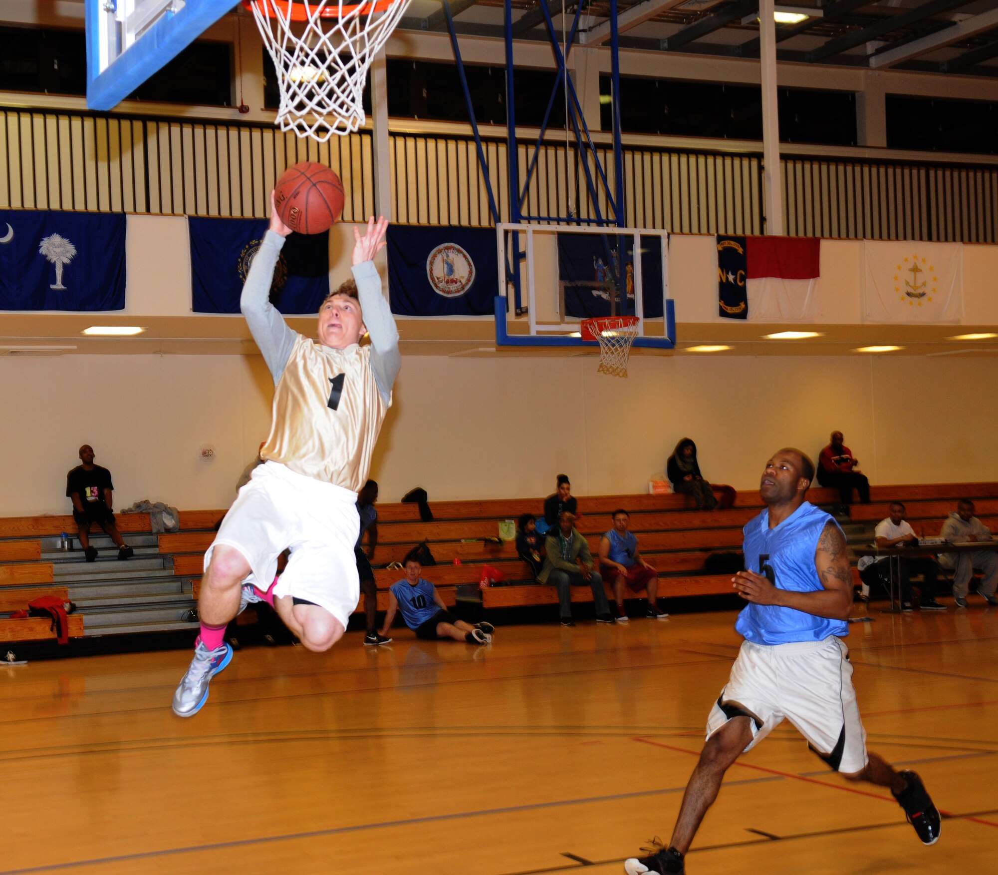 Airman 1st Class Caleb Johnson, left, 100th Operations Support Squadron airfield manager, jumps for a layup while Tech. Sgt. Richard Brown, 352nd Special Operations Support Squadron NCO in charge of intelligence operations, gives chase during an intramural basketball game between the 100th Operations Group and the 352nd Special Operations Support Squadron Jan. 10, 2013, at the Hardstand Fitness Center on RAF Mildenhall, England. The 352nd SOSS were victorious over the 100th OG with a score of 55-41. (U.S. Air Force photo by Airman 1st Class Dillon Johnston/Released)