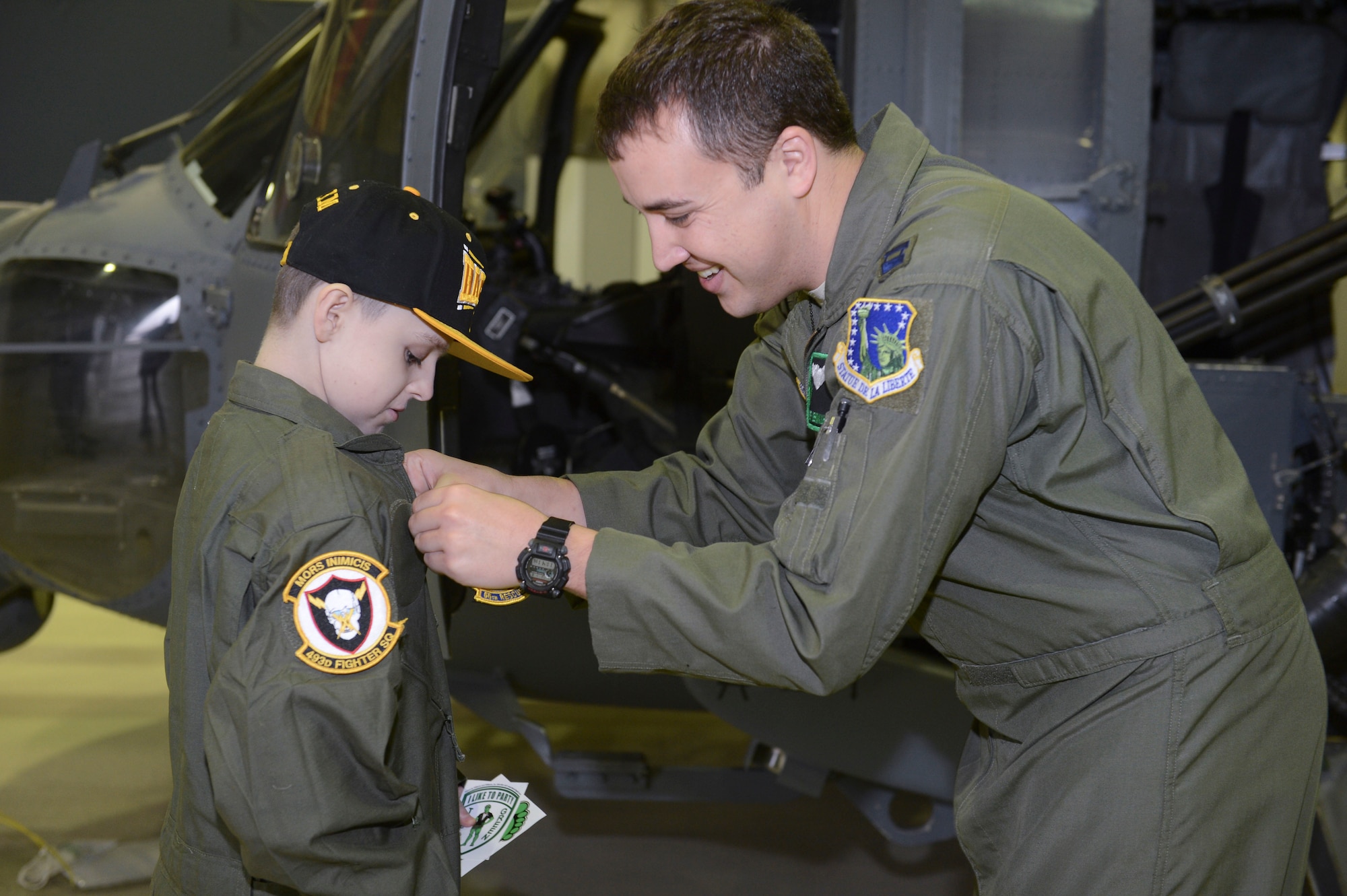 ROYAL AIR FORCE LAKENHEATH, England - Capt. Jeff Lehmkuhl, 56th Rescue Squadron chief of current operations and native of San Bernardino, Calif., gives a unit patch to Dawson Davidson, an 11-year-old Mildenhall resident, during a "Pilot for a Day" event Jan. 8, 2013. The "Pilot for a Day" program was started at RAF Lakenheath in March 2012 by Maj. Jason Bianchi, 493rd Fighter Squadron pilot, with the intent to assist children throughout local communities who are fighting life-threatening illnesses or conditions by providing a day of fun and allowing for a break from the routine doctor and hospital visits.  (U.S. Air Force photo by Staff Sgt. Stephen Linch)