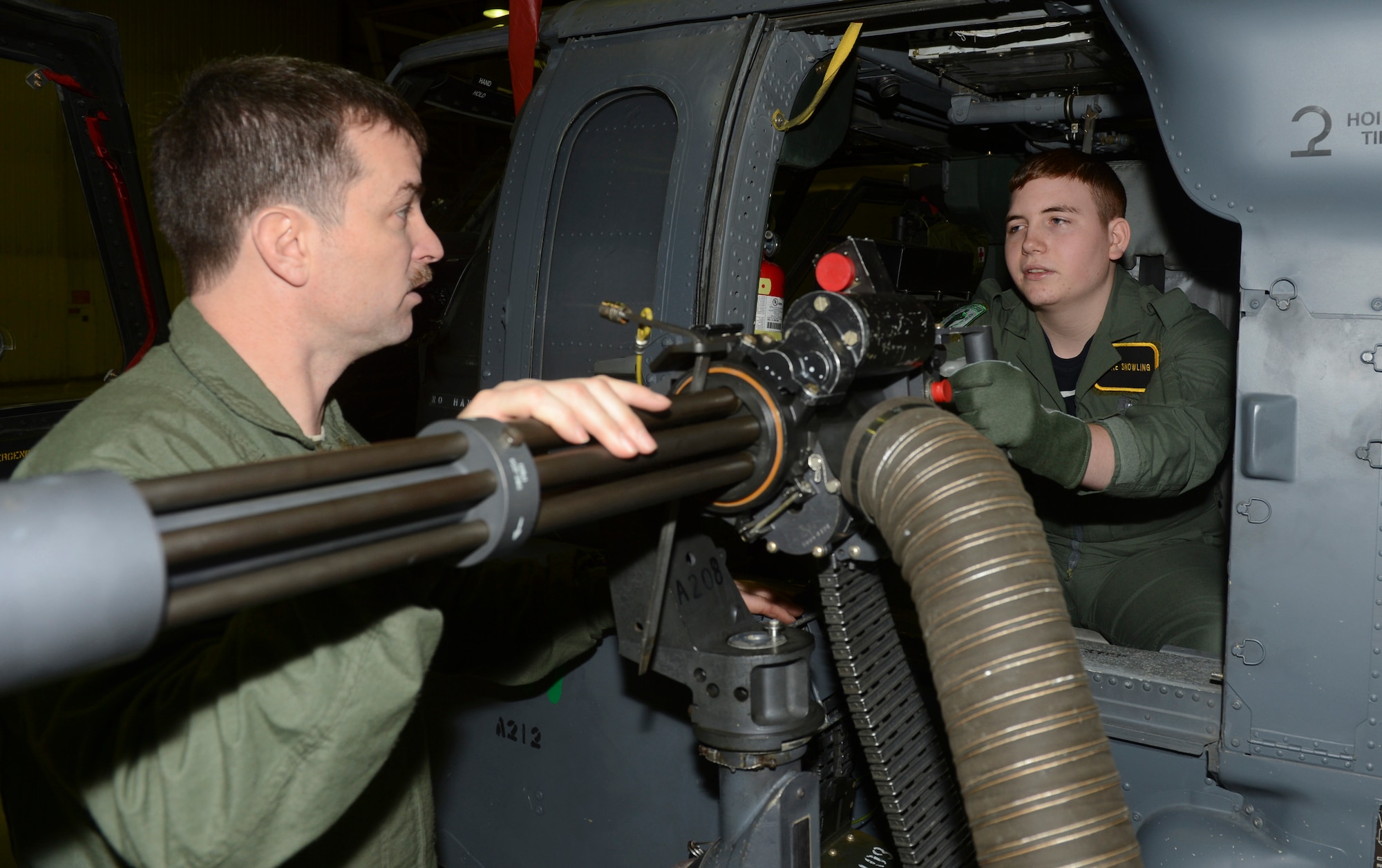 ROYAL AIR FORCE LAKENHEATH, England - Tech. Sgt. Patrick Ledbetter, 56th Rescue Squadron flight engineer and native of Wichita Falls, Texas, shows Jake Snowling, a 15-year-old Redgrave resident, a GAU-2C mini-gun on an HH-60G Pave Hawk during a "Pilot for a Day" event Jan. 8, 2013. During the event two local children received special-made flight suits, a flight in an F-15 simulator, an interactive squadron tour and an up-close viewing of an F-15C Eagle and HH-60G Pavehawk. (U.S. Air Force photo by Staff Sgt. Stephen Linch)