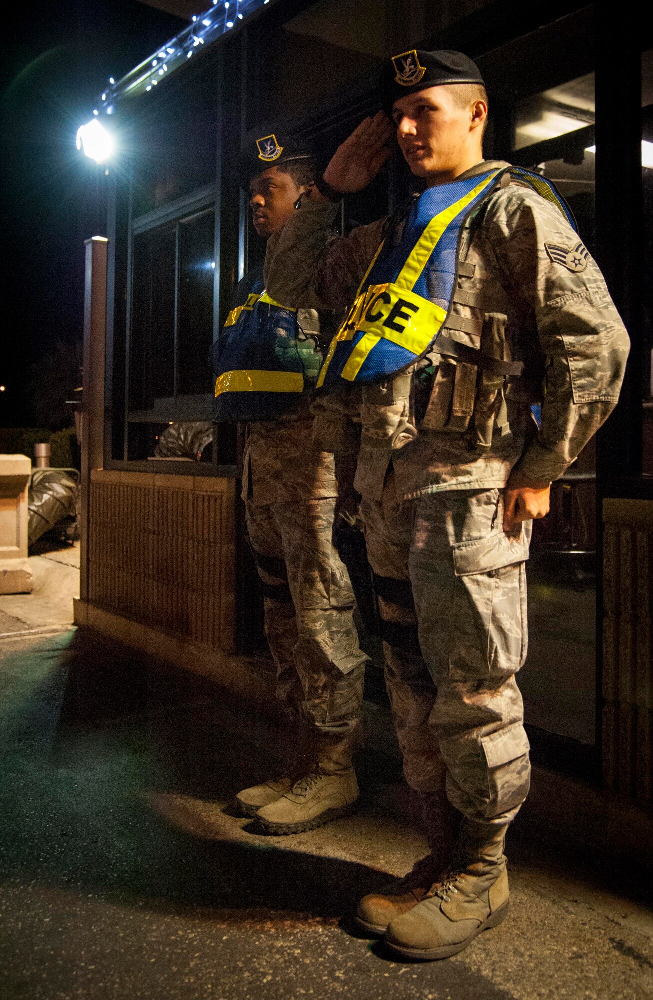 Senior Airman Alexander Hedgecock and Airman 1st Class James Little, 47th Security Forces Squadron patrolmen, demonstrate how to perform a post brief to those of senior rank who request at the main gate of Laughlin Air Force Base, Texas, Jan. 7, 2013. No matter what weather conditions are prevailing or what holiday it may be, there will always be a gate guard standing ready year round. (U.S. Air Force photo/Airman 1st Class Nathan Maysonet)
