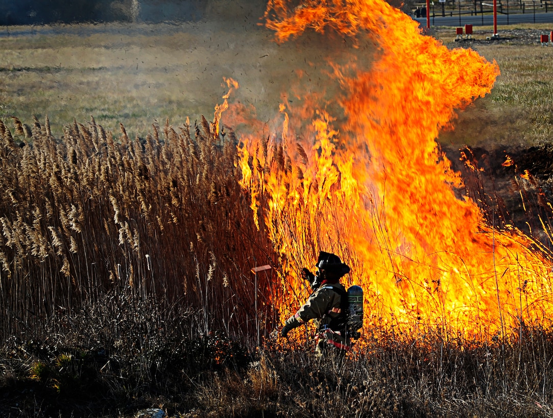 JOINT BASE ANDREWS, Md., - Tech. Sgt. Roger Dupuis, 11th Civil Engineering Squadron assistant chief of training ignites a fire on the flightline here during a controlled burn Jan. 10, 2013. The fire department conducted the burn to decrease the potential for Bird Aircraft Strike Hazards. (U.S. Air Force photo/Senior Airman Lauren Main)