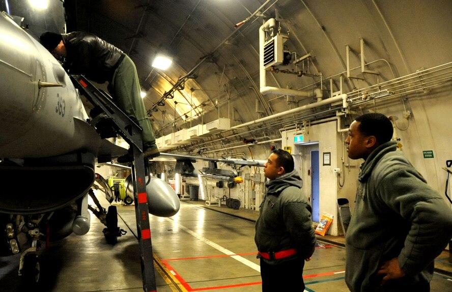 U.S. Air Force Staff Sgt. Nathan Jake Legaspi Perez, back, and Airman Basic Jeremy Franklin, 13th Aircraft Maintenance Unit crew chiefs, stand by while an F-16 Fighting Falcon is being inspected for their real-world trip to Guam at Misawa Air Base, Japan, Jan. 11, 2013. During the base-wide Initial Readiness Response Exercise, maintainers were generating jets for a simulated war-time scenario and a real-world training exercise. (U.S. Air Force photo by Airman 1st Class Kenna Jackson)