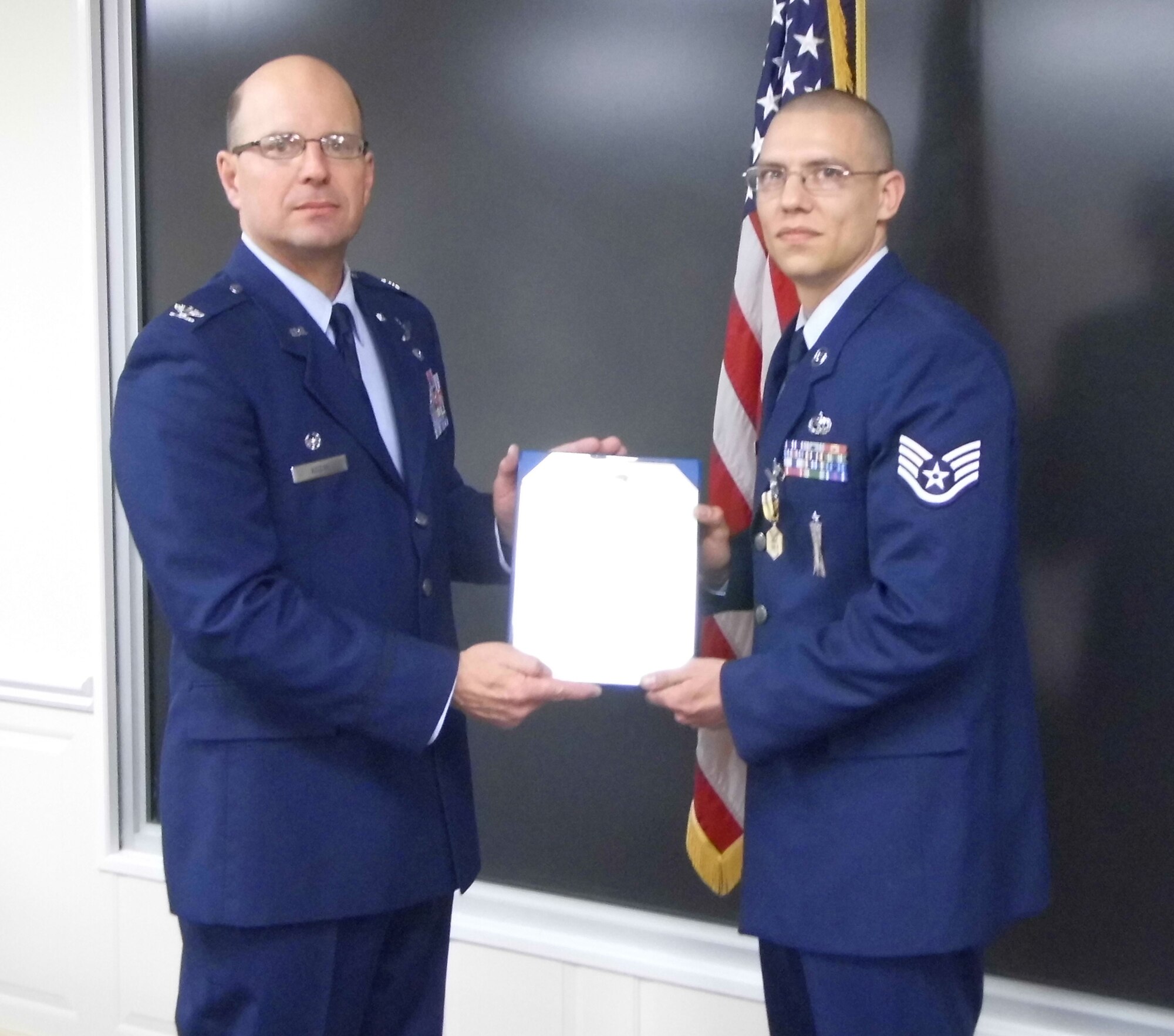 Col. Raymond A. Kozak, 512th Airlift Wing commander, presents the citation for an Air Force Commendation Medal to Staff Sgt. Michael Zadroga, 512th AW weapons safety manager, Jan. 5, 2013, at Dover Air Force Base, Del. The award was in recognition of Zadroga’s service as a munitions systems craftsman and as a weapons safety manager from 2008 to 2012. (U.S. Air Force photo/Senior Airman Joe Yanik)