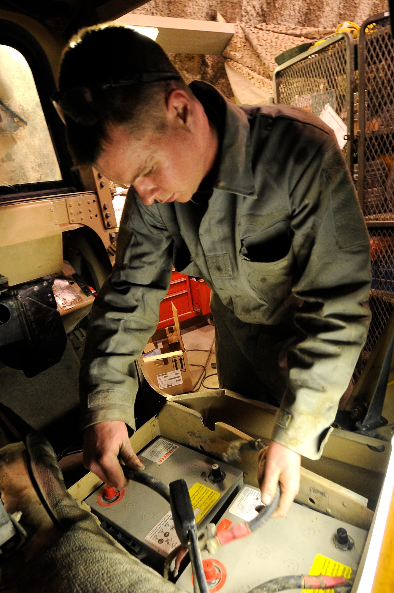 Senior Airman Scott Beahen, 455th Logistic Readiness Group tactical vehicle mechanic, installs an upgraded battery cell on an armored humvee on Bagram Airfield, Jan. 9, 2013. The tactical vehicle shop is responsible for maintaining weapon systems vehicles. (U.S. Air Force Photo/Master Sgt. Jun Kim)