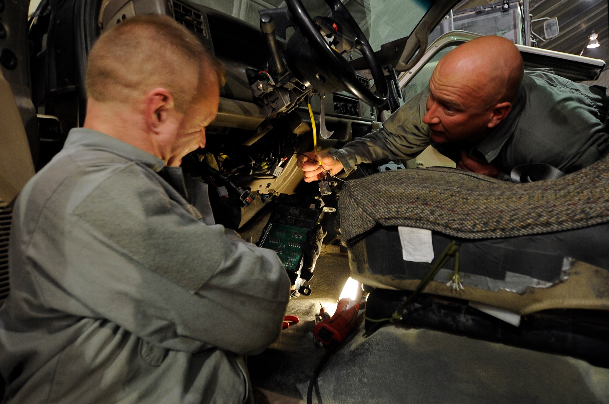 Tech. Sgt. Al Casterwiler (left) and Staff Sgt. Thomas Trzeciak, 455th Logistic Readiness Group vehicle mechanics, troubleshoot an electrical problem on a towing tractor on Bagram Airfield, Jan. 9, 2013. (U.S. Air Force Photo/Master Sgt. Jun Kim)