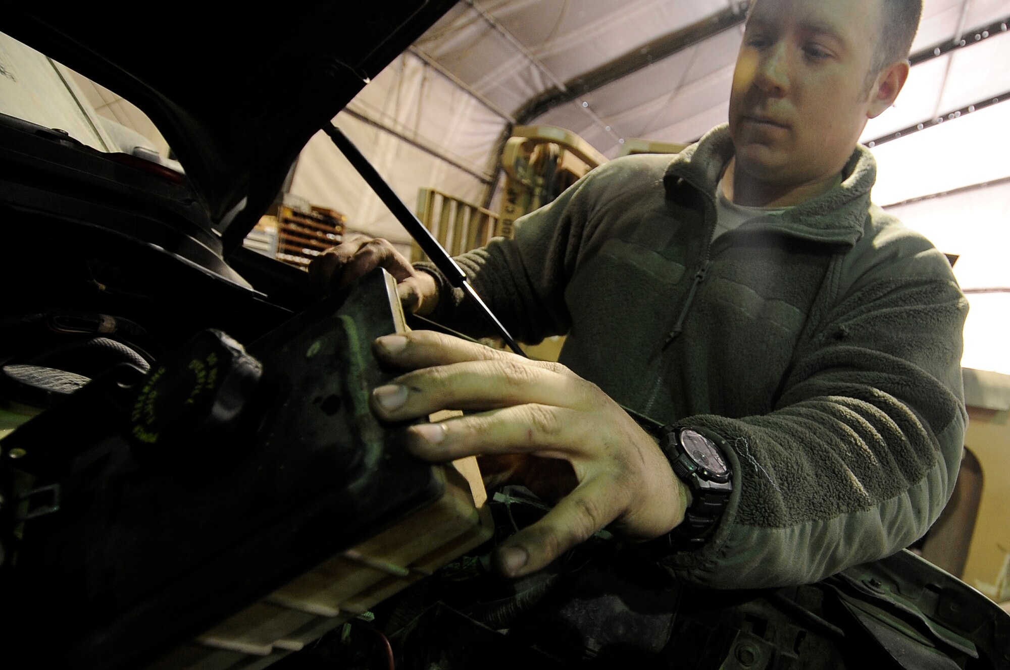 Staff Sgt. Michael Botti, 455th Logistic Readiness Group vehicle mechanic, removes the power steering reservoir off the truck on Bagram Airfield, Jan. 9, 2013. The vehicle maintenance shop performs major repairs to include transmission, engine and power train. (U.S. Air Force Photo/Master Sgt. Jun Kim)