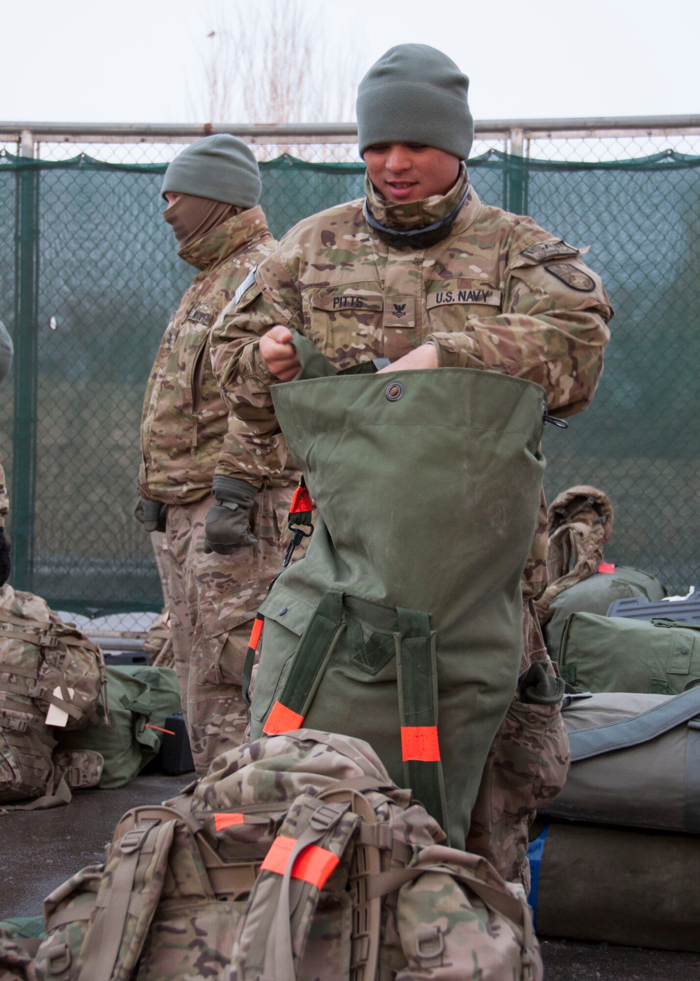 U.S. Navy Petty Officer 1st Class Ronald Pitts, a logistics specialist redeploying from Kandahar, Afghanistan, organizes his duffel bag during a bag drag at Transit Center at Manas, Kyrgyzstan, Jan. 3, 2013. Pitts was part of one of the first few groups of Sailors to process through the Transit Center as the Navy adjusts its Warrior Transition Program and the redeployment process. (U.S. Air Force photo/ Tech. Sgt. Rachel Martinez)