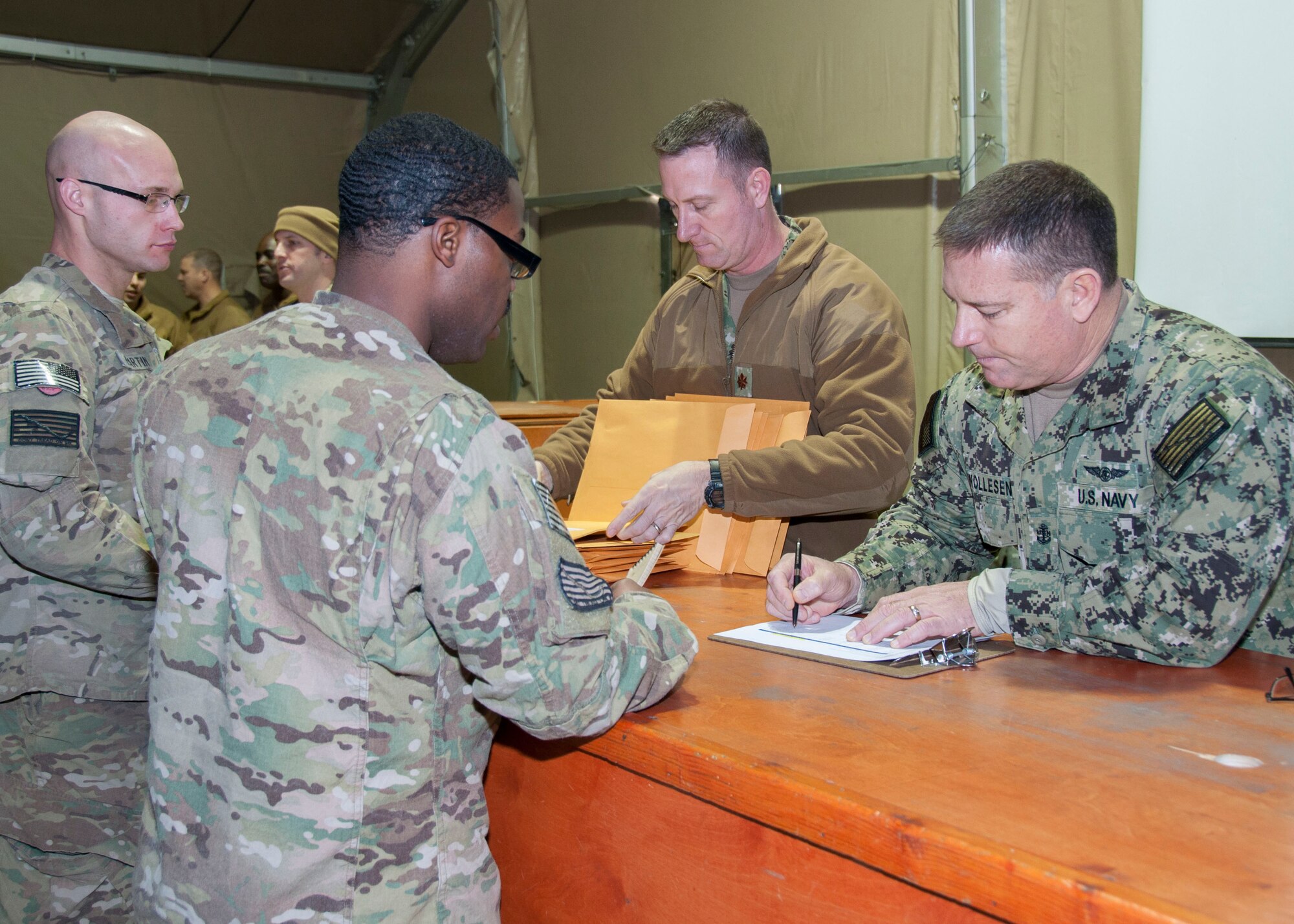 Right, U.S. Navy Chief Petty Officer David Wollesen, U.S. Naval Forces Central Command Forward Headquarters Manas chief of operations, and Lt. Cmdr. Christopher Dahl, NFHQ Manas operations officer, check in Sailors and provide them with necessary documents prior to their redeployment from Transit Center at Manas, Kyrgyzstan, Jan. 10, 2013. The NFHQ Manas staff assists Sailors with their onward travel itineraries and pay issues during multi-day stay at the Transit Center. (U.S. Air Force photo/Tech. Sgt. Rachel Martinez)