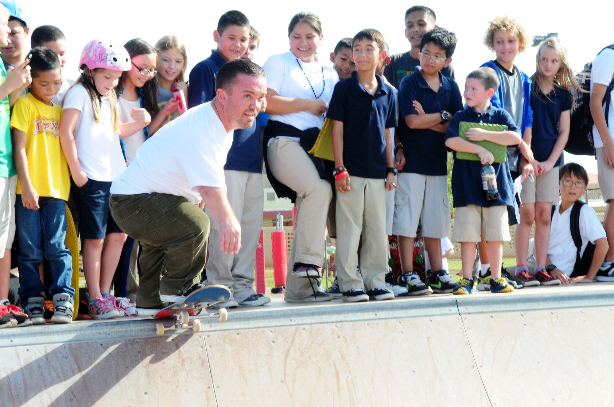 Actor Jason “Wee Man” Acuña performs a trick on the half pipe, as Team Andersen youth cheer him on at the skate park on Andersen Air Force Base, Guam, Jan. 9. Wee Man signed autographs, raffled prizes, conducted a skateboard demonstration and previewed his newest movie for Airmen and family members at Andersen as part of his Wee Man Salutes the Service tour. (U.S. Air Force photo by Senior Airman Robert Hicks/Released)