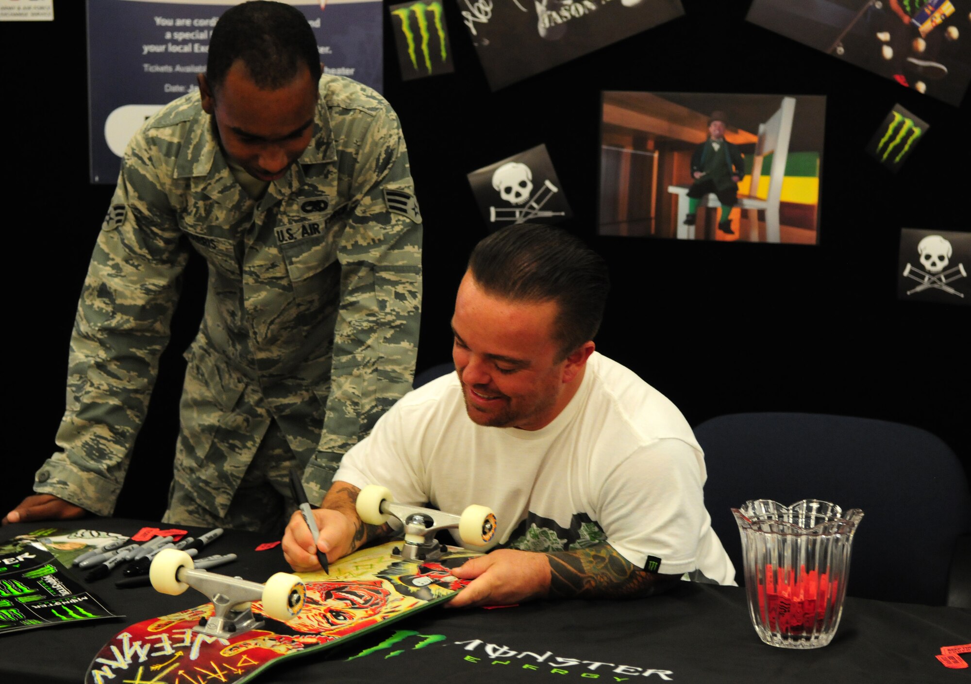 Actor Jason “Wee Man” Acuña autographs a skateboard that Senior Airman Lyndon Harris, 734th Air Mobility Squadron, won in a raffle drawing at the Base Exchange on Andersen Air Force Base, Guam, Jan. 9. Wee Man Signed autographs, raffled prizes, conducted a skateboard demonstration and previewed his newest movie for Airmen and family members at Andersen as part of his Wee Man Salutes the Service tour. (U.S. Air Force photo by Senior Airman Robert Hicks/Released)