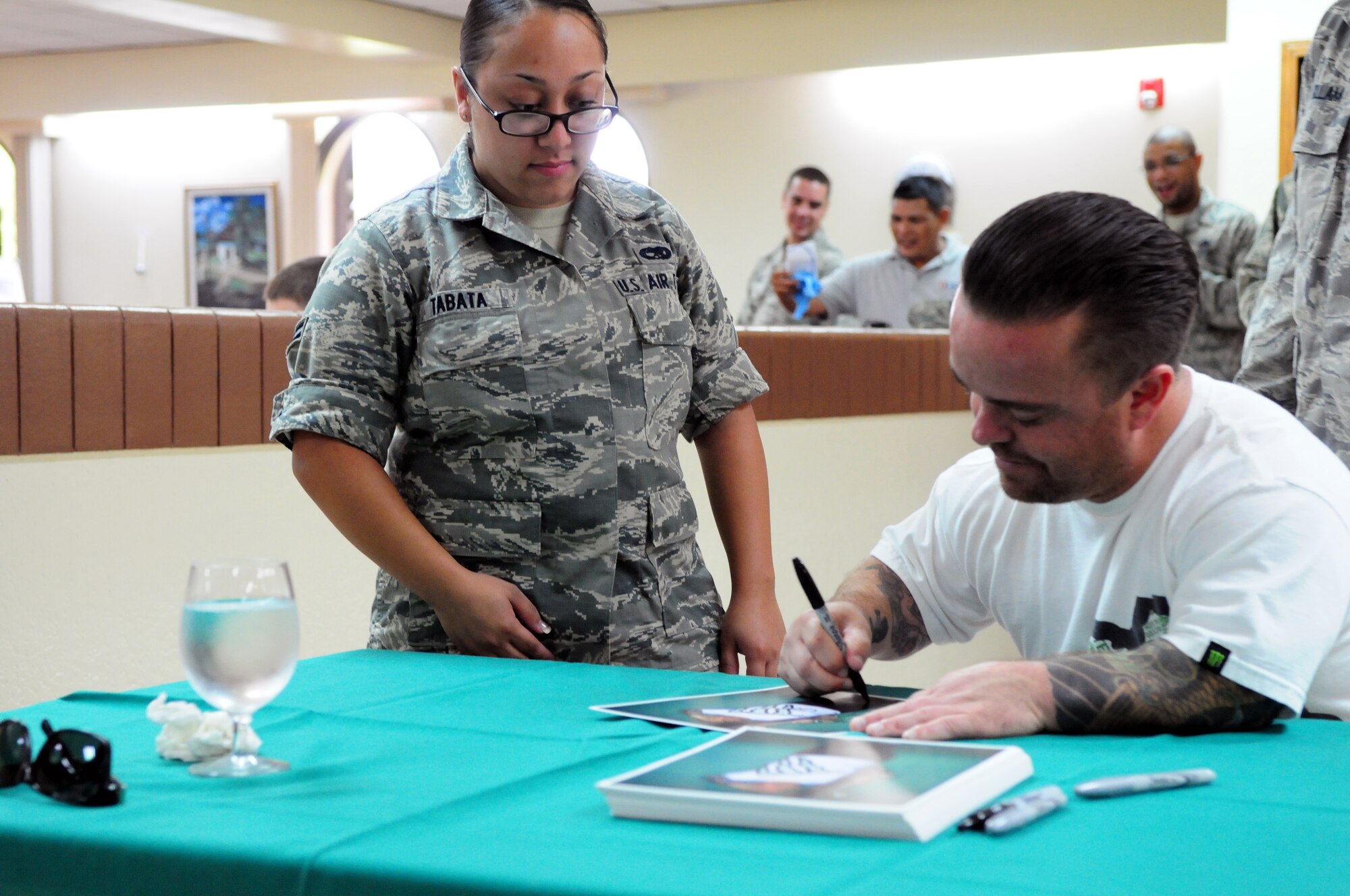 Actor Jason “Wee Man” Acuña signs an autograph for Airman 1st Class Kealahni Tabata, 36th Munitions Squadron, at the Magellan Inn Dining Facility on Andersen Air Force Base, Guam, Jan. 9. Wee Man Signed autographs, raffled prizes, conducted a skateboard demonstration and previewed his newest movie for Airmen and family members at Andersen as part of his Wee Man Salutes the Service tour. (U.S. Air Force photo by Senior Airman Robert Hicks/Released)