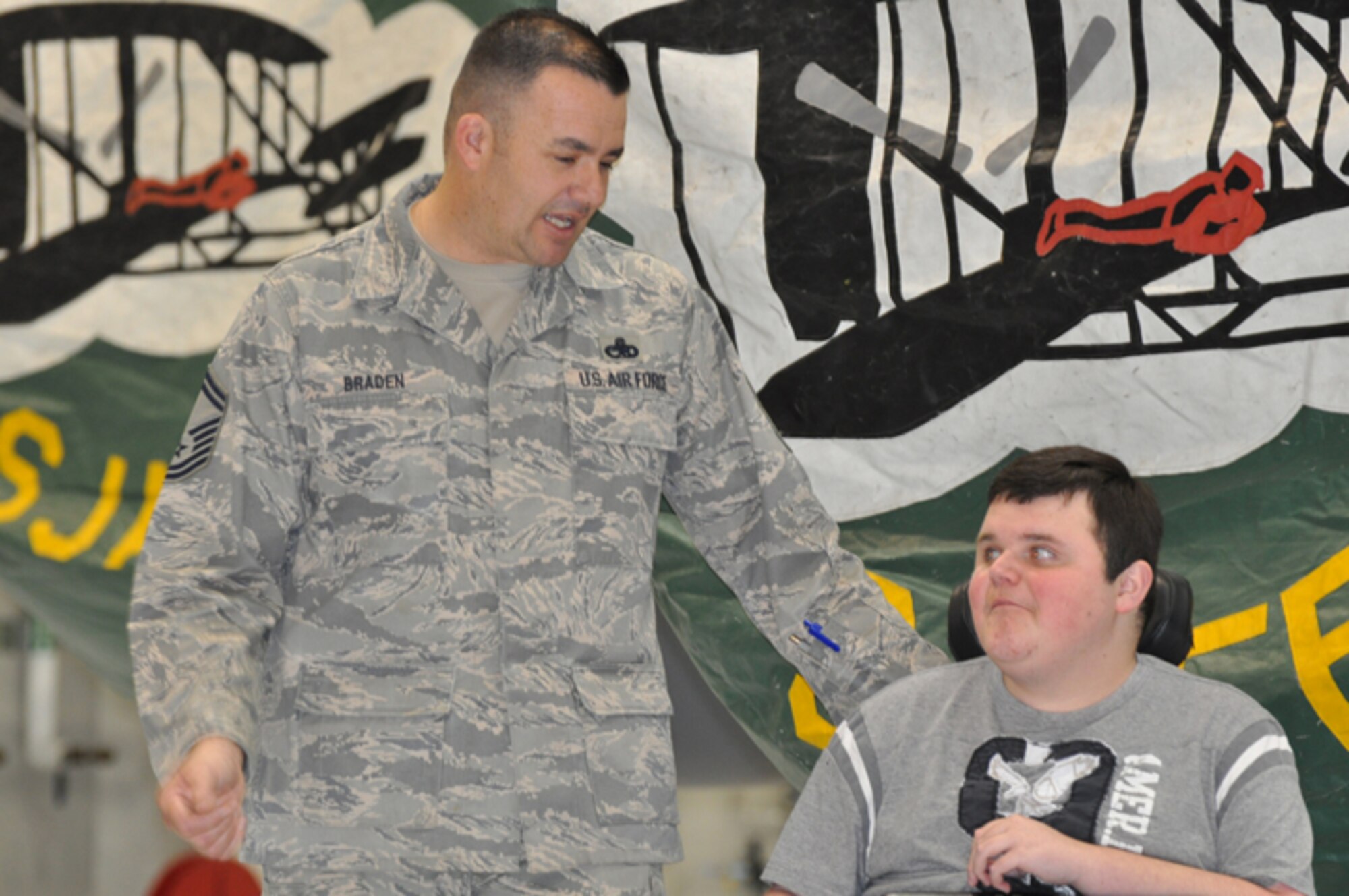 Senior Master Sgt. Joe Braden talks with Parrish, his camper during Camp Carefree, during a tour of a KC-135R Stratotanker on Jan. 11, 2013. Braden set up a tour of Seymour Johnson for 11 youth with muscular dystrophy. (USAF photo by Maj. Shannon Mann, 916ARW/PA)
