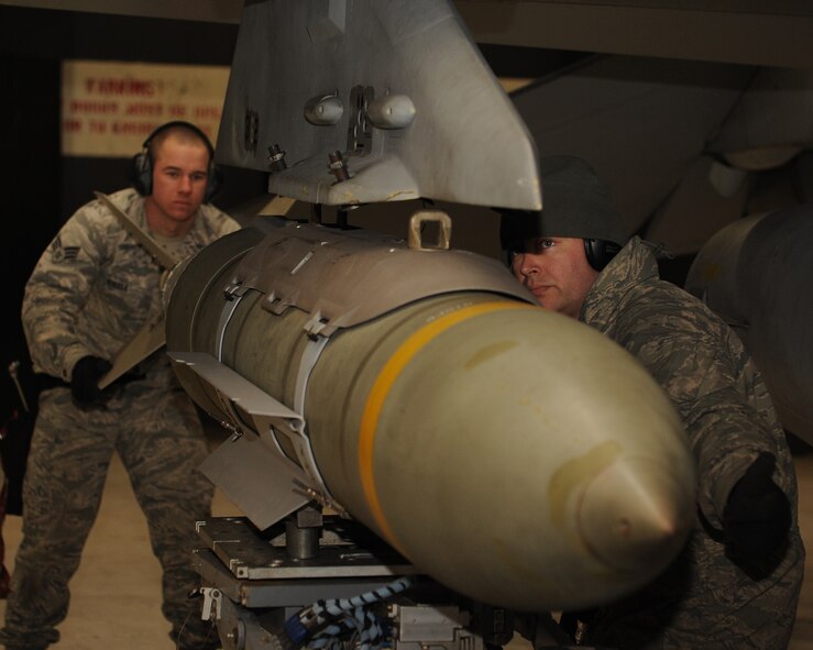 Senior Airman Kristopher Steele, left, and Staff Sgt. Chad Smith, 8th Aircraft Maintenance Squadron, ensure a bomb is aligned while loading it onto an F-16 Fighting Falcon at Kunsan Air Base, Republic of Korea, Jan. 14, 2013. This was part of Beverly Midnight 13-1, an exercise which tests the capabilities and readiness of Kunsan personnel. (U.S. Air Force photo by Staff Sgt. Jonathan Fowler/Released)