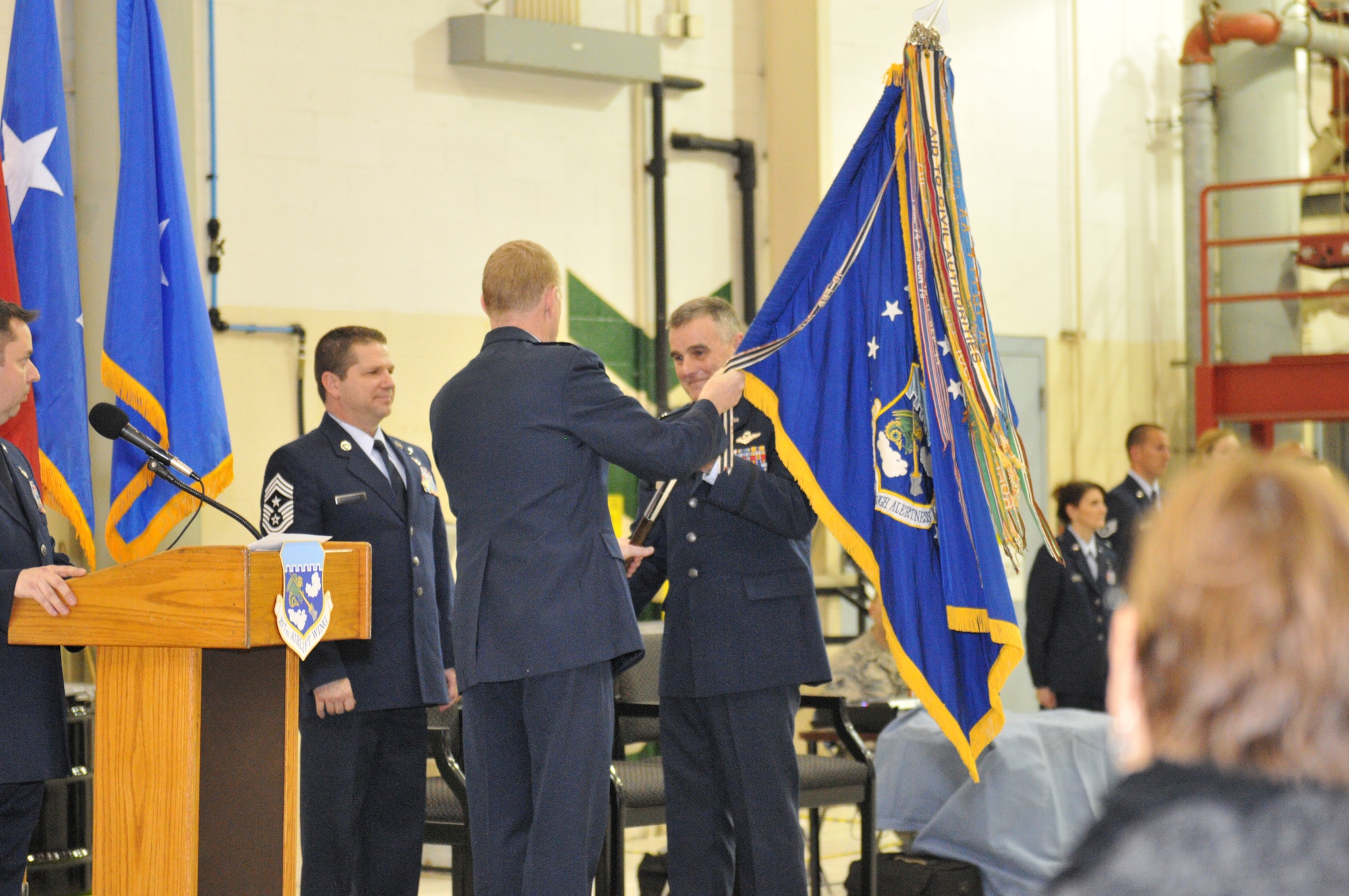 Major General Verle Johnston, the commander of the New York Air National Guard hands the 107th Airlift Wing's flag to Col. John Higgins as he assumes command at the Niagara Falls Reserve Station on Jan. 12, 2013 (Air National Guard Photo//Senior Master Sgt. Stephan Kovacs)
