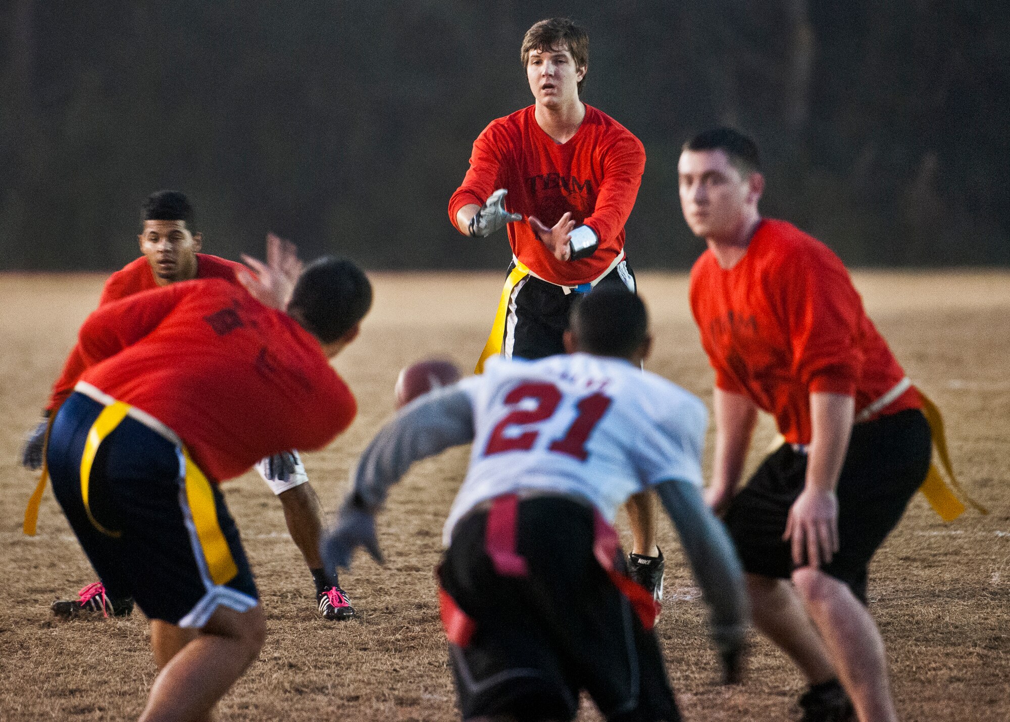 Brett Bryant, the Contracting Team quarterback, takes the snap during a play at the goal of the 96th Medical Group during the base intramural championship game Jan. 9 at Eglin Air Force Base, Fla.  The Medical Group won easily 33-16. (U.S. Air Force photo/Samuel King Jr.)