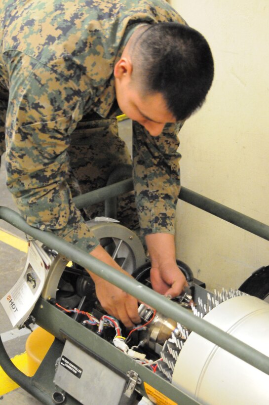 MARINE CORPS BASE QUANTICO, Va. (Jan. 11) – Sgt. Luis Sevila, a warehouse cleck for supply platoon, The Basic School, replaces the charred filter of a downed field tent heater at TBS supply warehous. Behind the scenes, Supply platoon is responsible for tracking the beans, bullets and Band-aids for all of The Basic School.