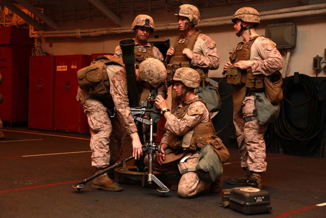 Marines with Gun Team 4, 81mm Mortars/Tactical Recovery of Aircraft and Personnel Platoon, Weapons Company, Battalion Landing Team 3/5, 15th Marine Expeditionary Unit, practice gun drills in the hangar bay of the USS Peleliu, Jan. 6. The 15th Marine Expeditionary Unit is deployed as part of the Peleliu Amphibious Ready Group as a U.S. Central Command theater reserve force, providing support for maritime security operations and theater security cooperation efforts in the U.S. 5th Fleet area of responsibility. (U.S. Marine Corps photo by Cpl. John Robbart III)