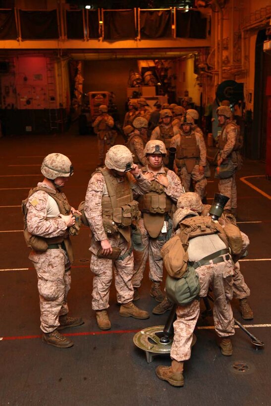 Marines with 81mm Mortars/Tactical Recovery of Aircraft and Personnel Platoon, Weapons Company, Battalion Landing Team 3/5, 15th Marine Expeditionary Unit, practice gun drills in the hangar bay of the USS Peleliu, Jan. 6. The 15th Marine Expeditionary Unit is deployed as part of the Peleliu Amphibious Ready Group as a U.S. Central Command theater reserve force, providing support for maritime security operations and theater security cooperation efforts in the U.S. 5th Fleet area of responsibility. (U.S. Marine Corps photo by Cpl. John Robbart III)