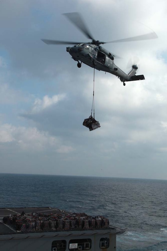 A MH-60S Knight Hawk with Combat Helicopter Squadron 23, USS Peleliu collects supplies from the USNS Alan Shepard during a replenishment-at-sea, Jan. 6. The 15th Marine Expeditionary Unit is deployed as part of the Peleliu Amphibious Ready Group as a U.S. Central Command theater reserve force, providing support for maritime security operations and theater security cooperation efforts in the U.S. 5th Fleet area of responsibility. (U.S. Marine Corps photo by Cpl. John Robbart III)