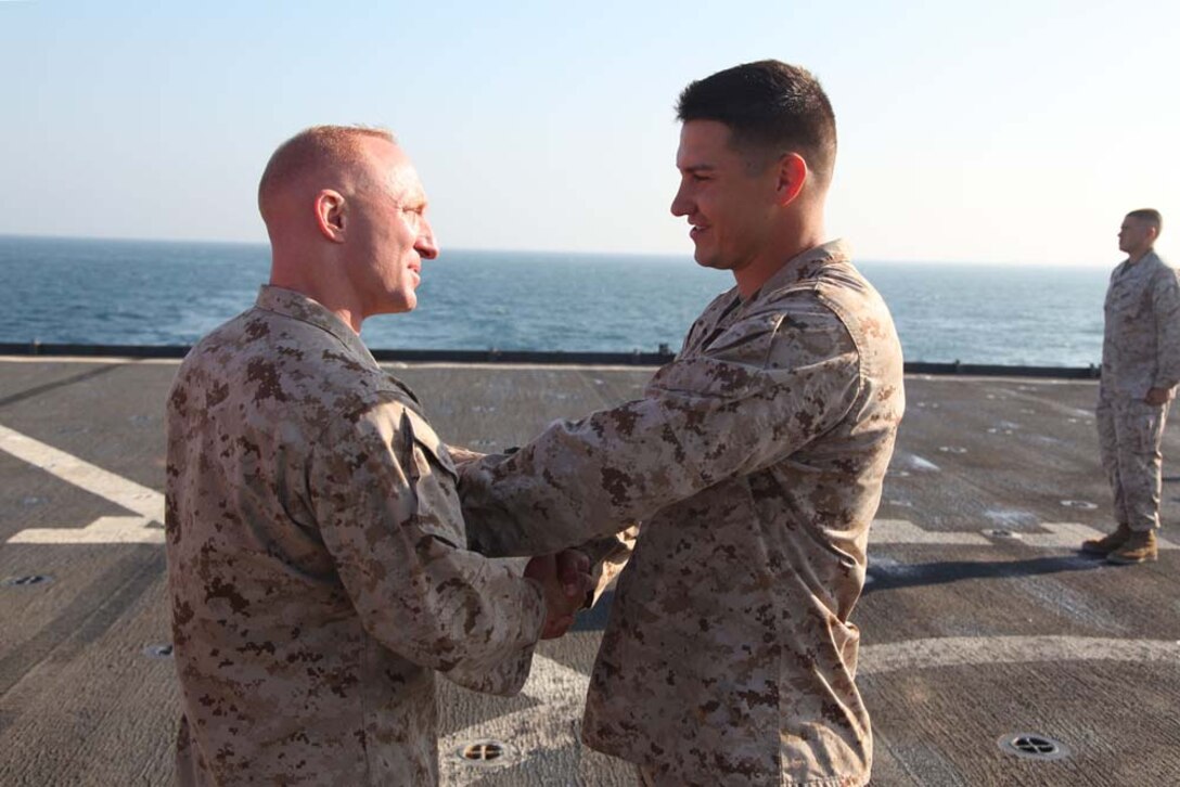 Corporal Kyle C. Sieradzki (right), artillery cannoneer, 2nd Platoon, Battery B, Battalion Landing Team 3/5, 15th Marine Expeditionary Unit, shakes hands with his batteryâ€™s commanding officer, Capt. Christopher Siekman, after being promoted to the rank of corporal aboard USS Rushmore, Dec. 24. The 15th MEU is deployed as part of the Peleliu Amphibious Ready Group as a U.S. Central Command theater reserve force, providing support for maritime security operations and theater security cooperation efforts in the U.S. 5th Fleet area of responsibility. (U.S. Marine Corps photo by Cpl. Timothy R. Childers)