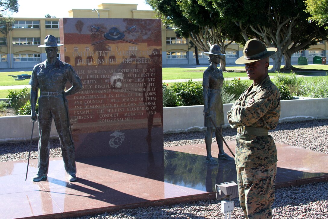 Sgt. Luckner L. Desma, drill instructor, Platoon 2169, Company H, 2nd Recruit Training Battallion looks on beside the Drill Instructor statue aboard Marine Corps Recruit Depot San Diego Dec. 27. Desma's tour as a drill instructor will end, once the recruits of Company H graduate recruit training.