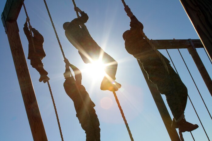Recruits of Company C, 1st Recruit Training Battalion, pull themselves up the rope at the end of the obstacle course aboard Marine Corps Recruit Depot San Diego Jan. 3. The exhausted recruits are forced to climb a rope after going through the course twice, which focuses on building upper-body strength. 