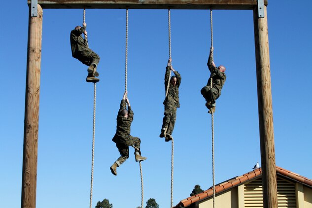 Recruits of Company C, 1st Recruit Training Battalion, pull themselves up the rope at the end of the obstacle course aboard Marine Corps Recruit Depot San Diego Jan. 3. The exhausted recruits are forced to climb a rope after going through the course twice, which focuses on building upper-body strength.
