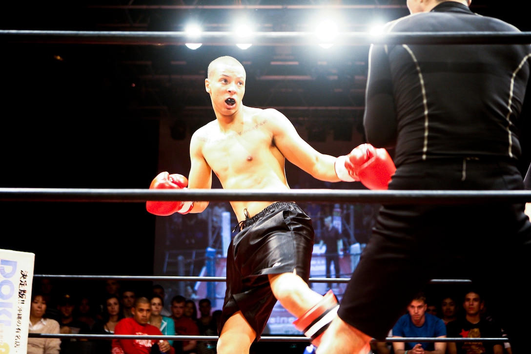 Cpl. Martin A. Minner prepares to engage his opponent during a kickboxing match Dec. 16 at Music Town Otoichiba in Okinawa City. Minner is one of two fighters who trained for three months with students from the Ryukyu Rehabilitation Academy. Minner is a field radio operator with 3rd Intelligence Battalion, III Marine Expeditionary Force Headquarters Group, III MEF.