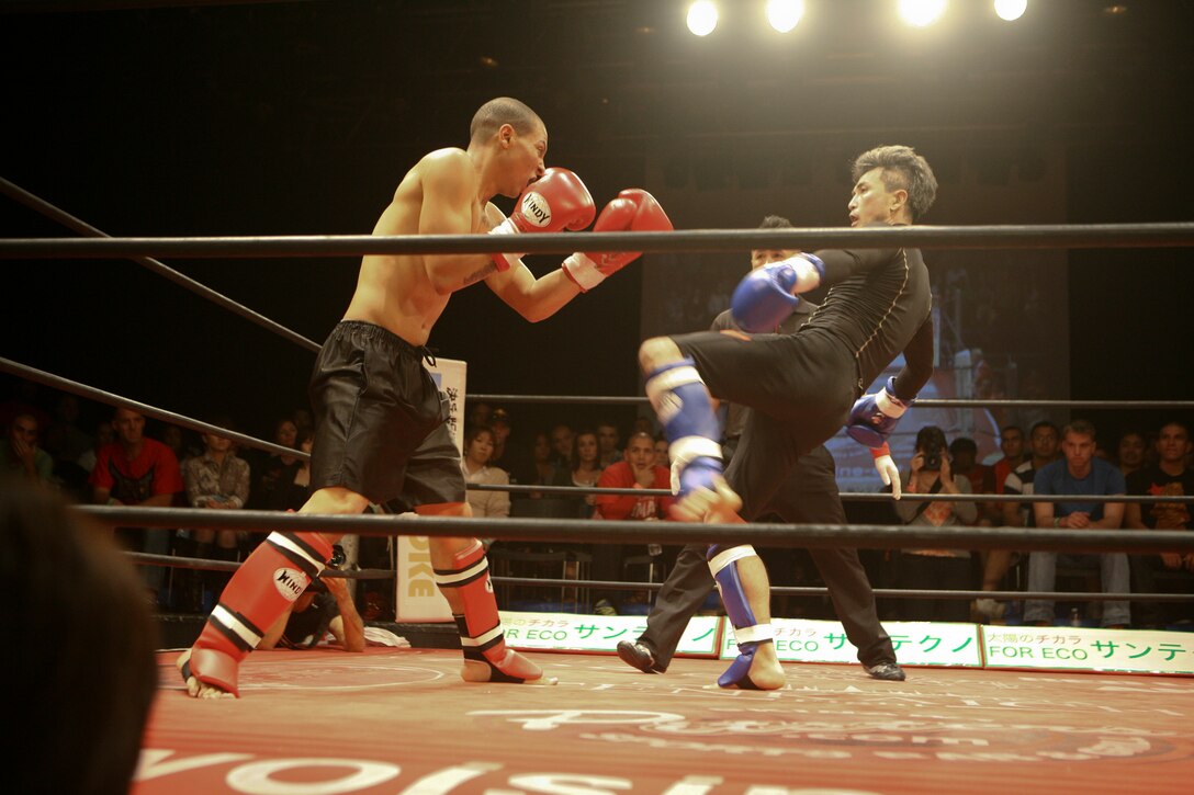 Cpl. Martin A. Minner, left, braces for impact during a kickboxing match Dec. 16 at Music Town Otoichiba in Okinawa City. The match was the culmination of three months of learning therapy skills and training alongside students with the Ryukyu Rehabilitation Academy. Minner is a field radio operator with 3rd Intelligence Battalion, III Marine Expeditionary Force Headquarters Group, III MEF.
