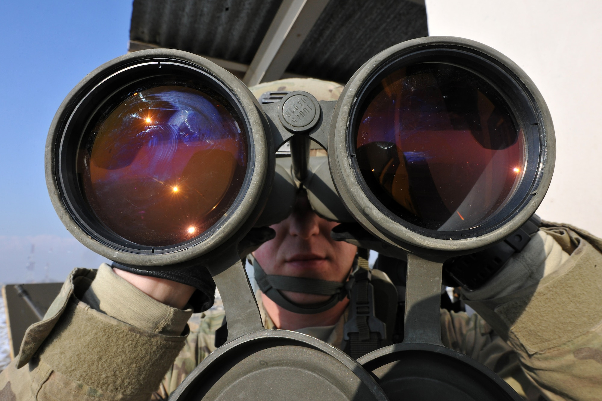 Airman 1st Class Lee Borytsky, 455th Expeditionary Security Forces Squadron defender, scans the perimeter around his guard tower on Bagram Airfield, Afghanistan, Jan. 10, 2013. The 455th ESFS mans the guard towers that ring the base, armed with powerful binoculars and other hi-tech surveillance gear, looking out into the local community and watching for any threats.  (U.S. Air Force photo/Senior Airman Chris Willis)