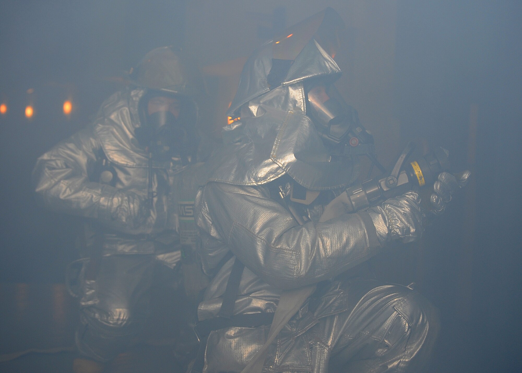 Tech. Sgt. Christopher Emerson and Senior Airman Kody Branson, both 8th Civil Engineer Squadron firefighters, put out a simulated fire while surrounded by smoke at Kunsan Air Base, Republic of Korea, Jan. 15, 2012. This was an exercise scenario for Beverly Midnight 13-1, which showcased the speed and effectiveness of Kunsan firefighters. (U.S. Air Force photo by Staff Sgt. Jonathan Fowler/Released)