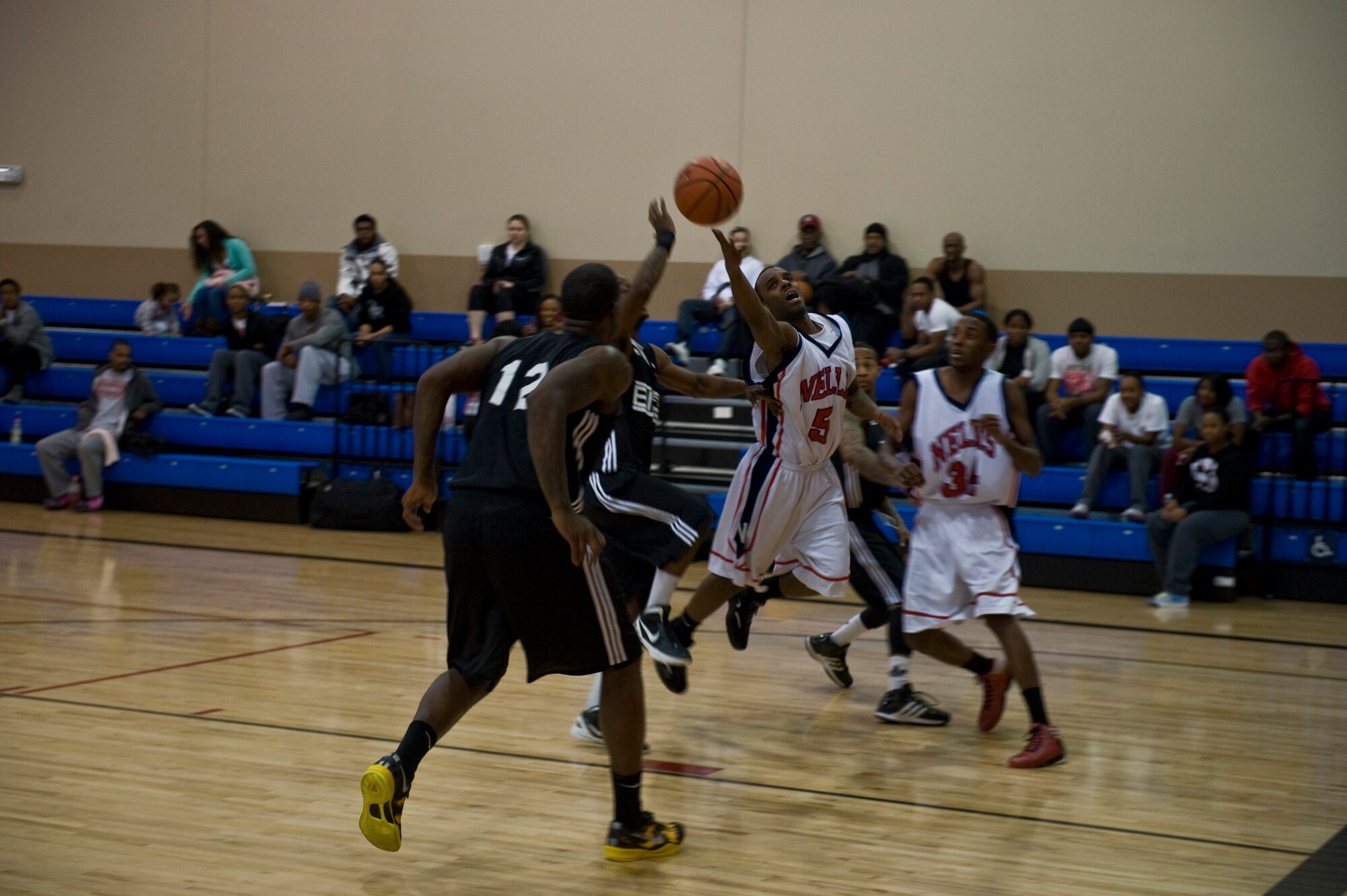 An Airman from the Nellis team gets fouled by a player from Fort Bliss, Texas, while attempting a lay-up in a Pacific West Military Basketball League game Jan. 12, 2013, at Nellis Air Force Base, Nev. The event included teams from Nellis, Fort Bliss, and Camp Pendleton. (U.S. Air Force photo by Senior Airman Daniel Hughes)