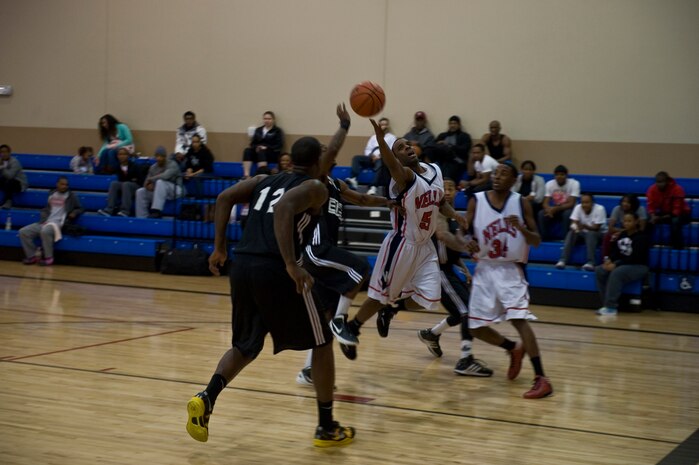 An Airman from the Nellis team gets fouled by a player from Fort Bliss, Texas, while attempting a lay-up in a Pacific West Military Basketball League game Jan. 12, 2013, at Nellis Air Force Base, Nev. The event included teams from Nellis, Fort Bliss, and Camp Pendleton. (U.S. Air Force photo by Senior Airman Daniel Hughes)