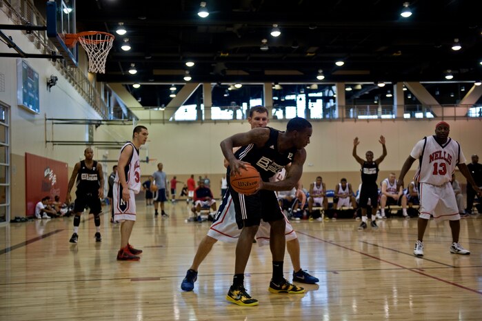 A Soldier from Fort Bliss, Texas, looks for an open man to pass the ball to during a game against Nellis, Jan. 12, 2013, at Nellis Air Force Base, Nev. Fort Bliss won their games against Nellis and Camp Pendleton during the Pacific West Military Basketball League at the Warrior Fitness Center. (U.S. Air Force photo by Senior Airman Daniel Hughes)