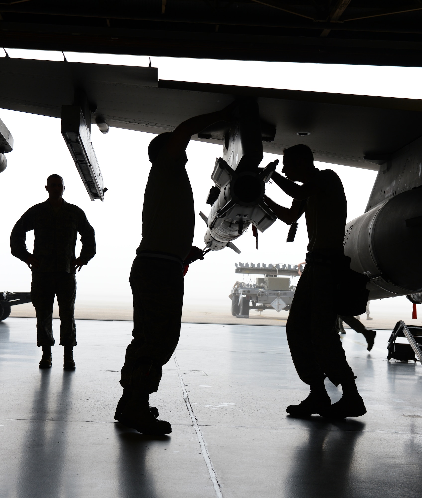U.S. Air Force Master Sgt. Niel Stockley, 20th Maintenance Operations Squadron loading standardization team chief, evaluates Senior Airman Jason Trexler and Staff Sgt. Joshua Humphreys, both 20th Aircraft Maintenance Squadron weapons load crew members, during a weapons load crew competition at Shaw Air Force Base, S.C., Jan. 11, 2013. During the fourth Weapons Load Crew of the Quarter competition, two crews competed to become eligible for the Load Crew of the Year. The winners were the 79th "Tigers." (U.S. Air Force photo by Senior Airman Tabatha Zarrella/Released)
