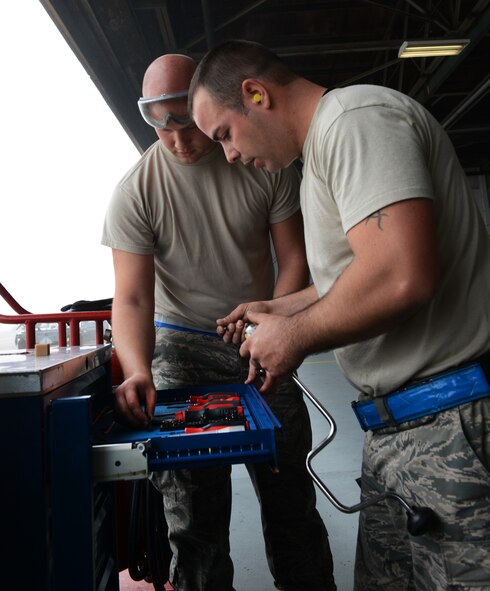 U.S. Air Force Airman 1st Class Kellan Arick, 20th Aircraft Maintenance Squadron weapons load crew member, and Staff Sgt. Joshua Brogden, 20th AMS weapons load crew member, select the necessary tools to complete their assigned tasks during a weapons load crew of the quarter competition, Shaw Air Force Base, S.C., Jan. 11, 2013. During the fourth Weapons Load Crew of the Quarter competition, two crews competed to become eligible for the Load Crew of the Year. The winners were the 79th "Tigers."  (U.S. Air Force photo by Senior Airman Tabatha Zarrella/Released)
