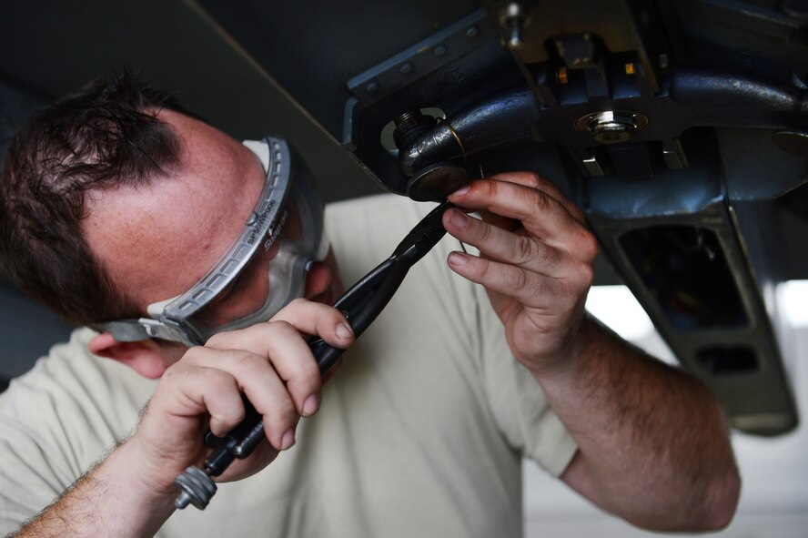 U.S. Air Force Senior Airman Ryan Ladda, 20th Aircraft Maintenance Squadron weapons load crew member, safety-wires the arming lanyard to the F-16 Fighting Falcon's weapon pylon sway brace at Shaw Air Force Base, S.C., Jan. 11, 2013. During the fourth Weapons Load Crew of the Quarter competition, two crews competed to become eligible for the Load Crew of the Year. The winners were the 79th "Tigers." (U.S. Air Force photo by Senior Airman Tabatha Zarrella/Released)
