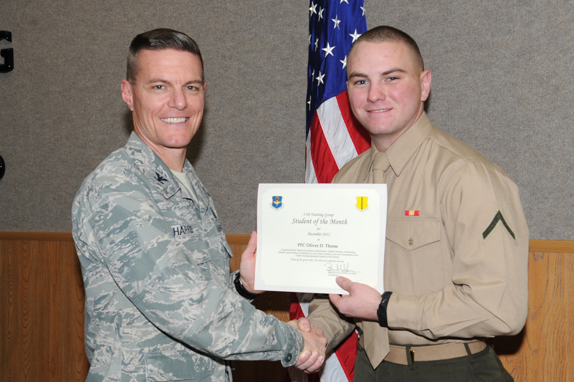 GOODFELLOW AIR FORCE BASE, Texas-- Col. Brendan Harris, 17th Training Group Commander, presents Marine Private 1st Class Oliver Threm with the 312th Training Squadron Student of the Month award for December, Jan. 11. (U.S. Air Force photo/Staff Sgt. Laura R. McFarlane)