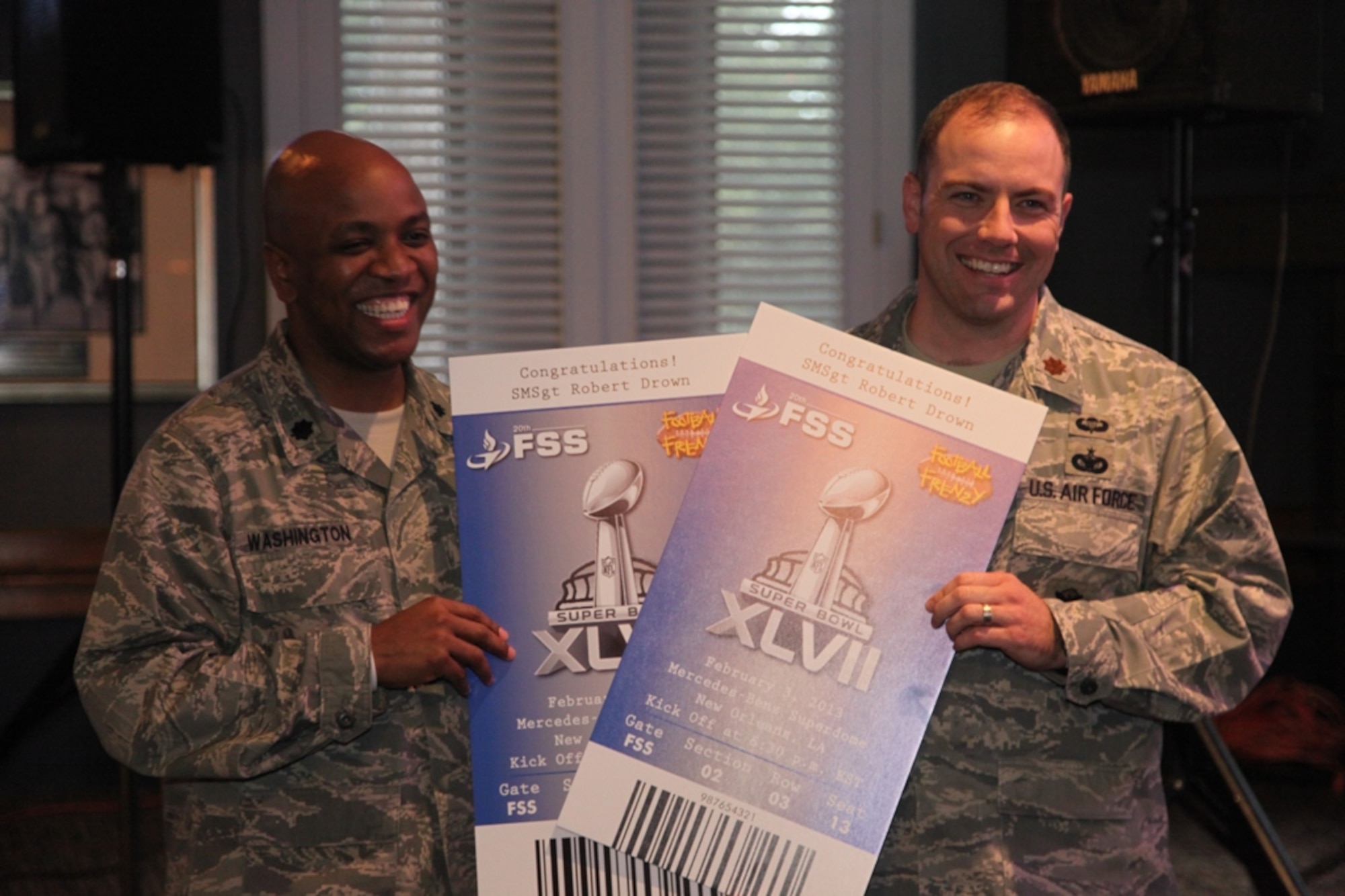 U.S. Air Force Lt. Col. Dalian Washington, 20th Force Support Squadron commander, presents Super Bowl tickets to Maj. Christopher Sheffield, 20th Security Forces Squadron commander on Senior Master Sgt. Robert Drown, 20th SFS’s superintendent behalf. (Courtesy photo by Elizabeth Washington)